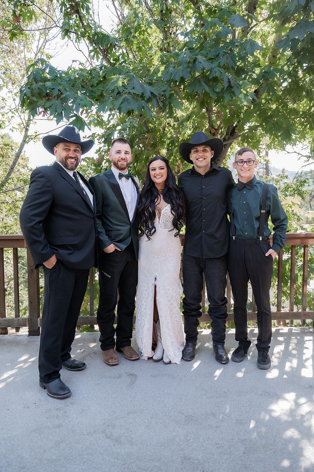 A bride and groom are posing for a picture with their wedding party.