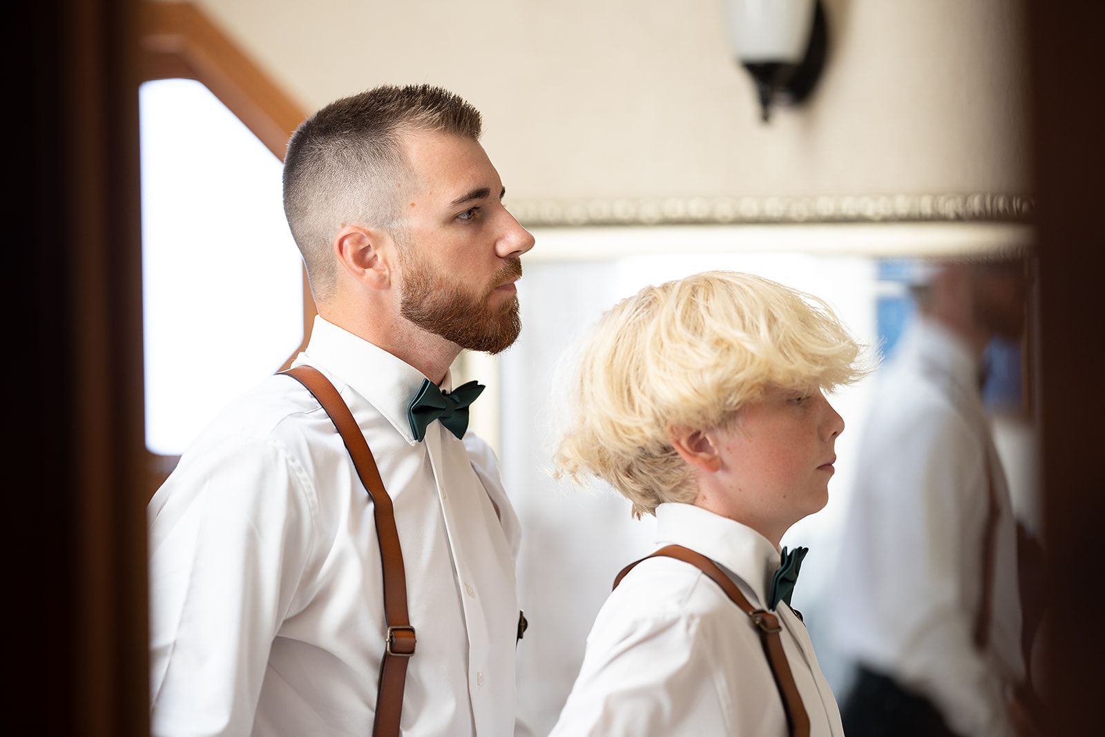 A man and a boy wearing suspenders and bow ties are standing next to each other.