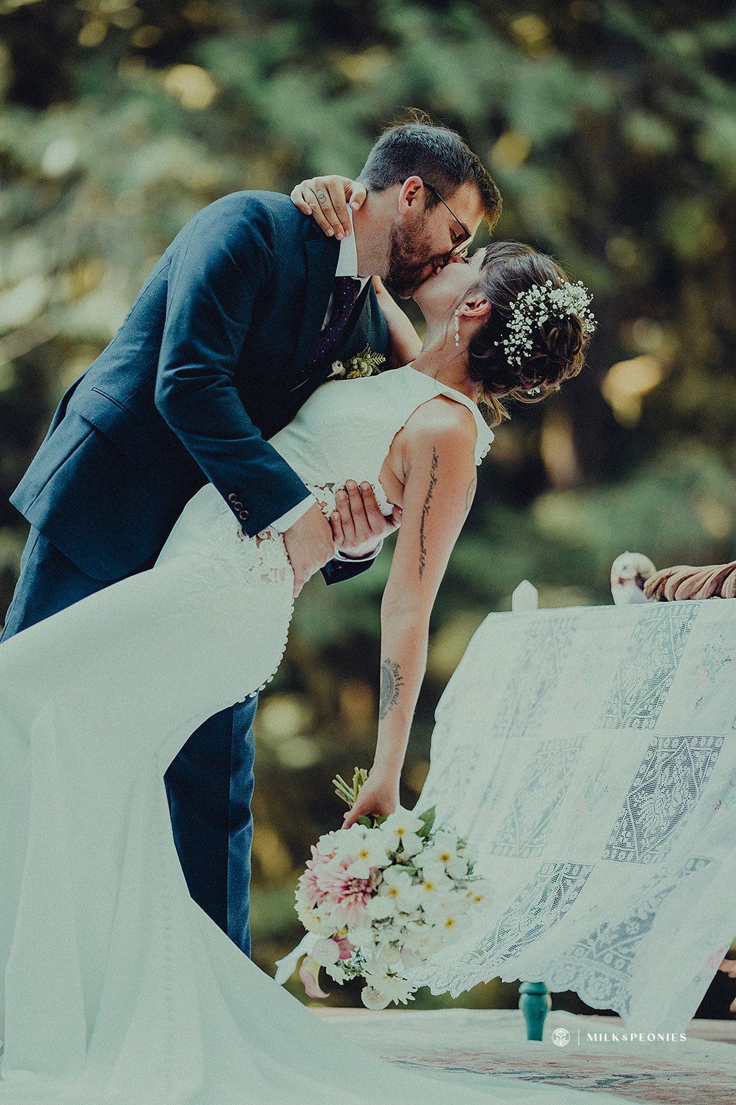 A bride and groom are kissing on their wedding day.