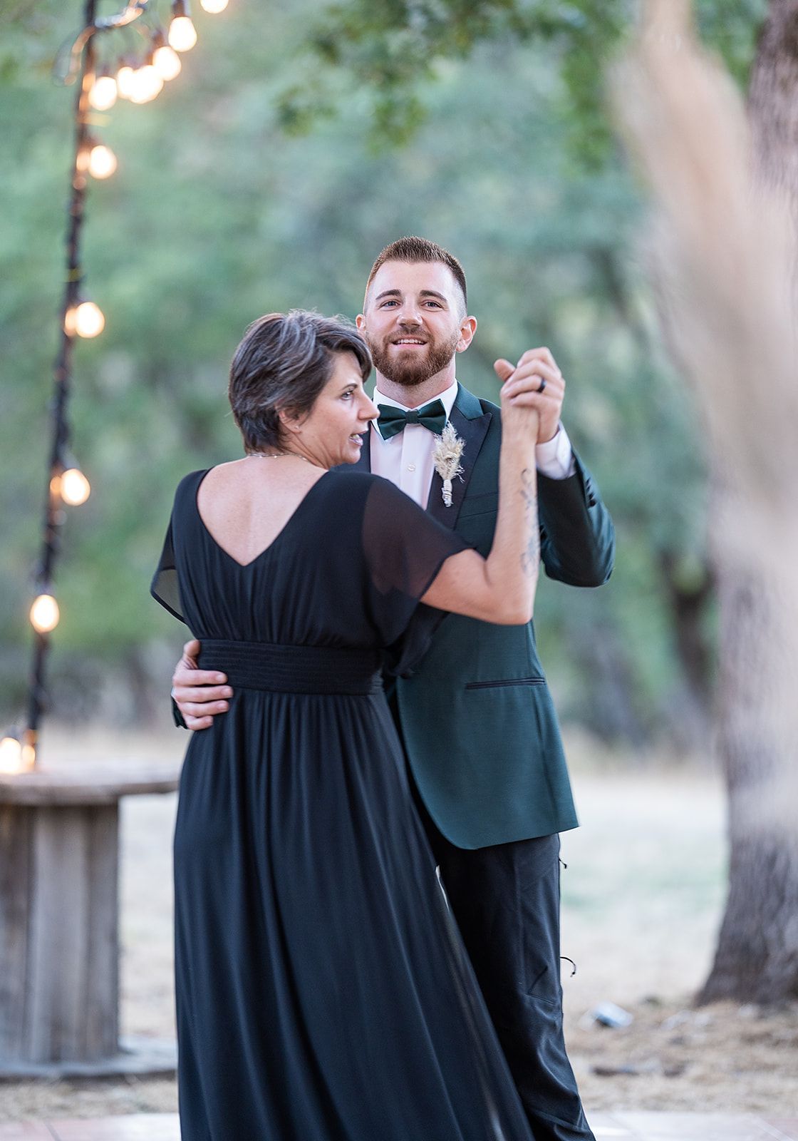 A bride and groom are dancing together at their wedding reception.