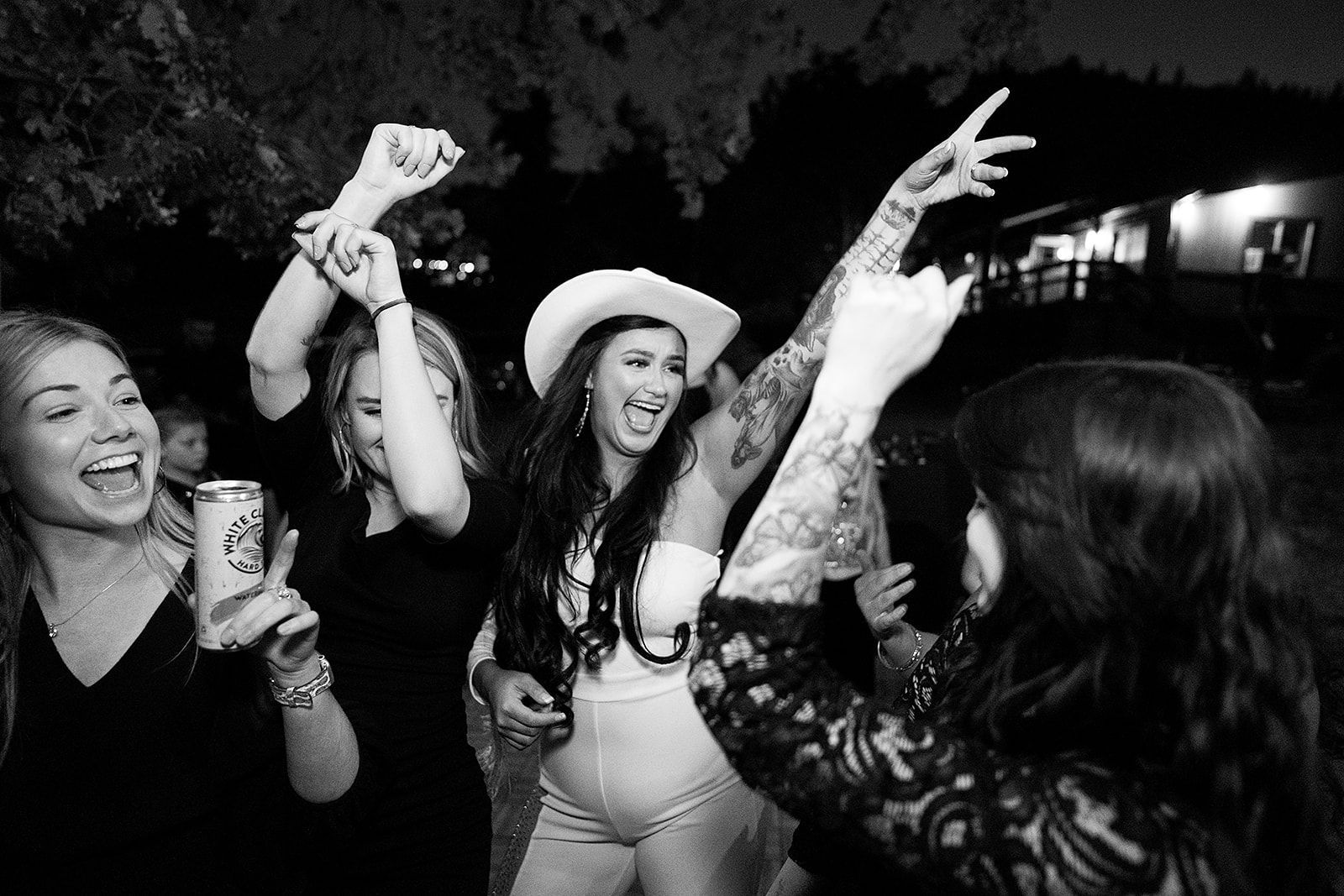 A black and white photo of a group of women dancing at a party.