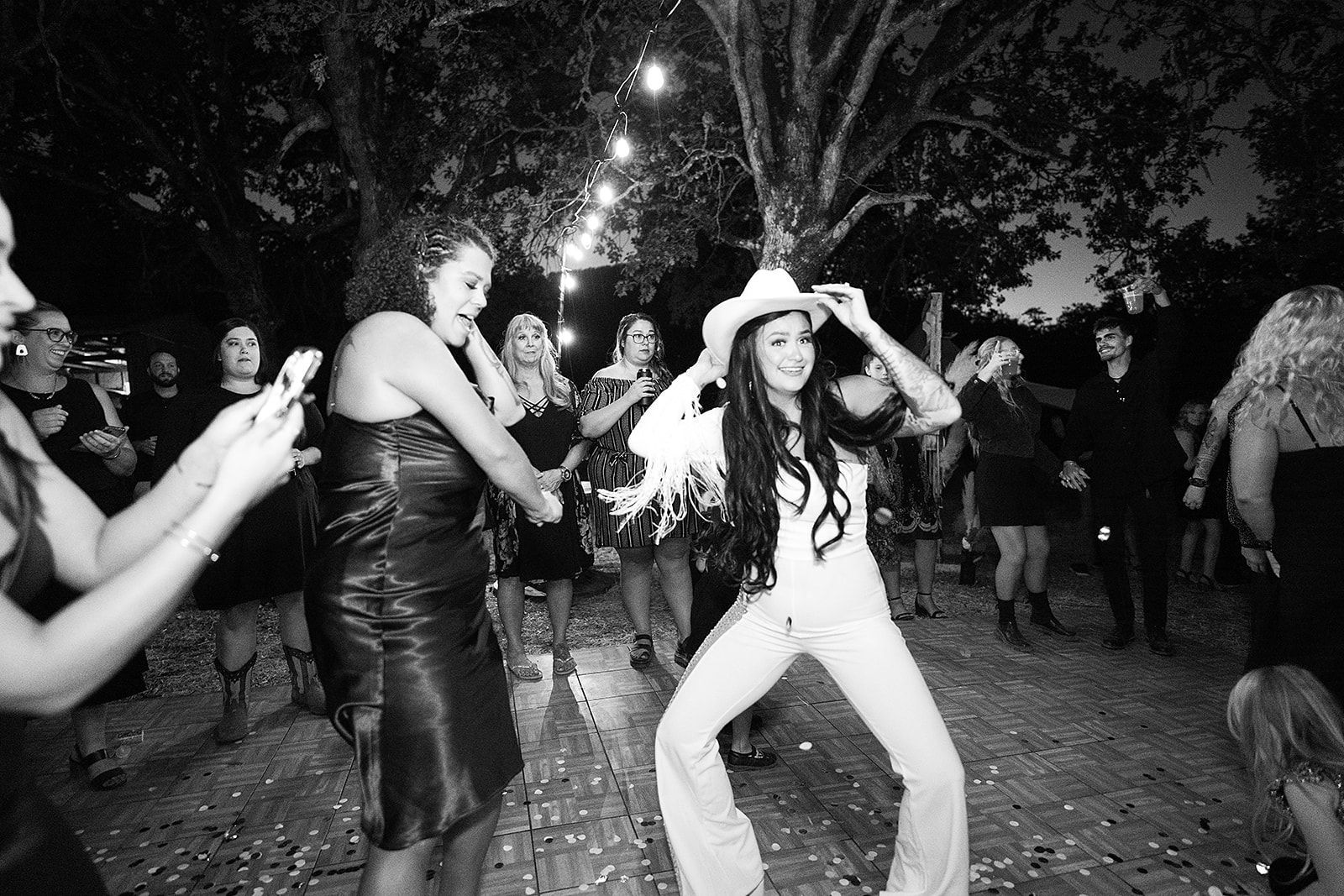 A group of women are dancing in a black and white photo.