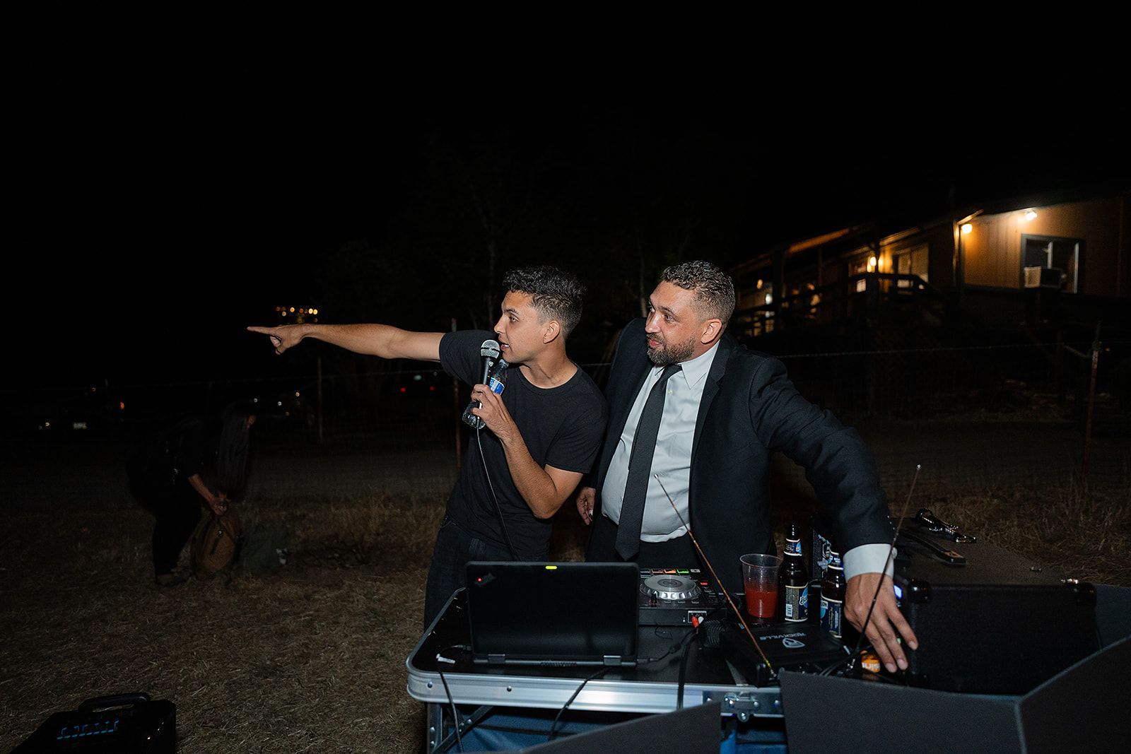 Two men are standing next to each other in front of a microphone.