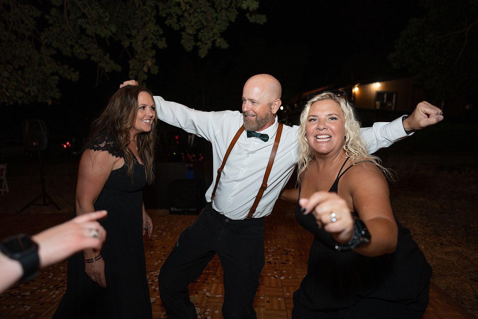A group of people are dancing together at a wedding reception.