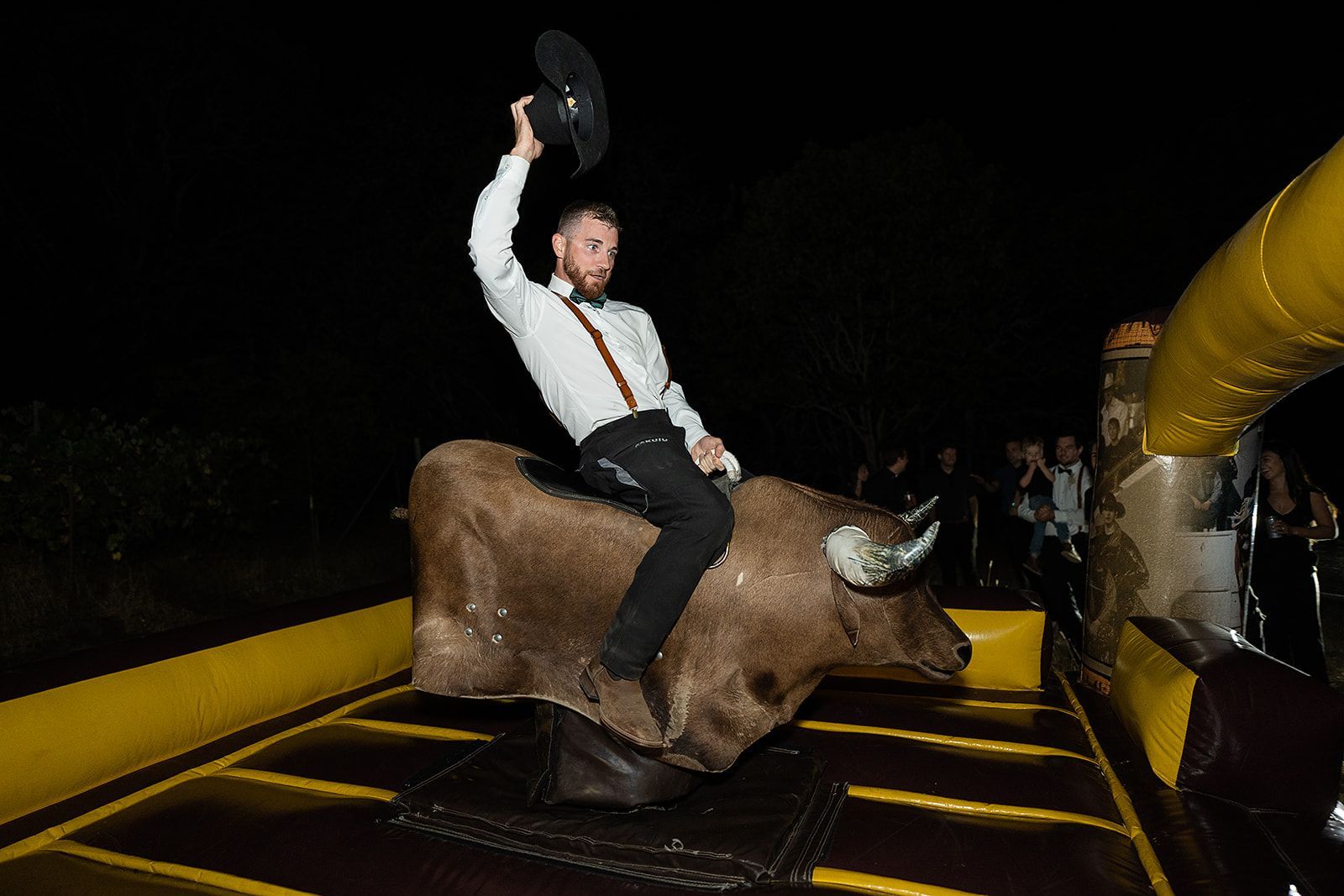 A man is riding a bull on a bouncy house.
