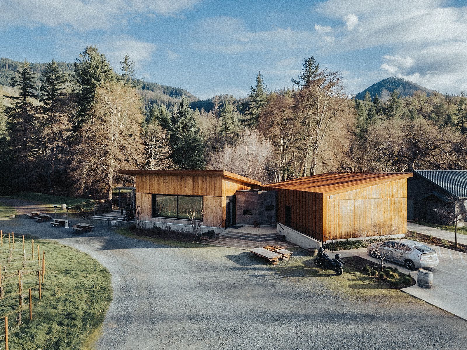 An aerial view of a house in the middle of a forest.