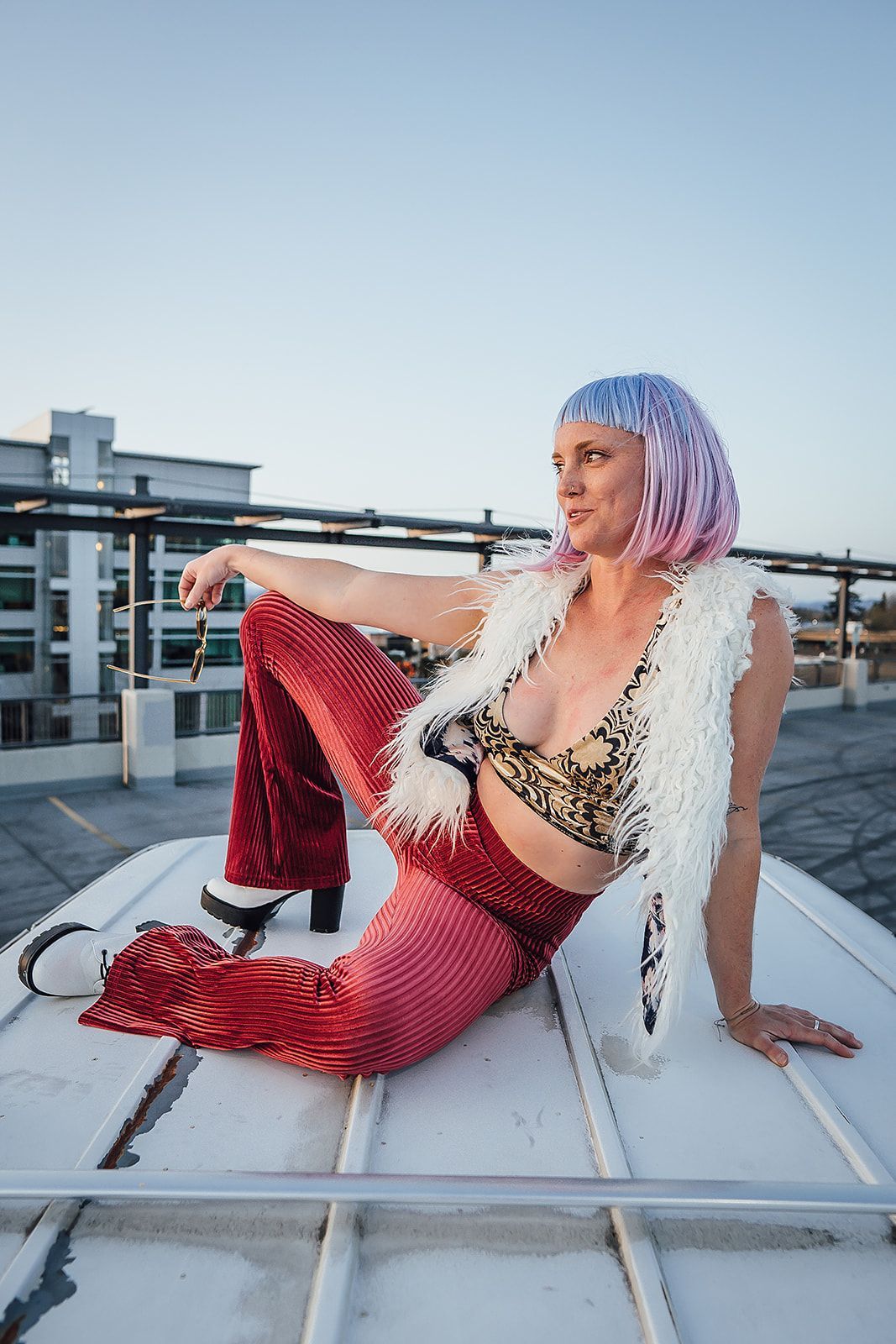 A woman with pink hair is sitting on a white boat.