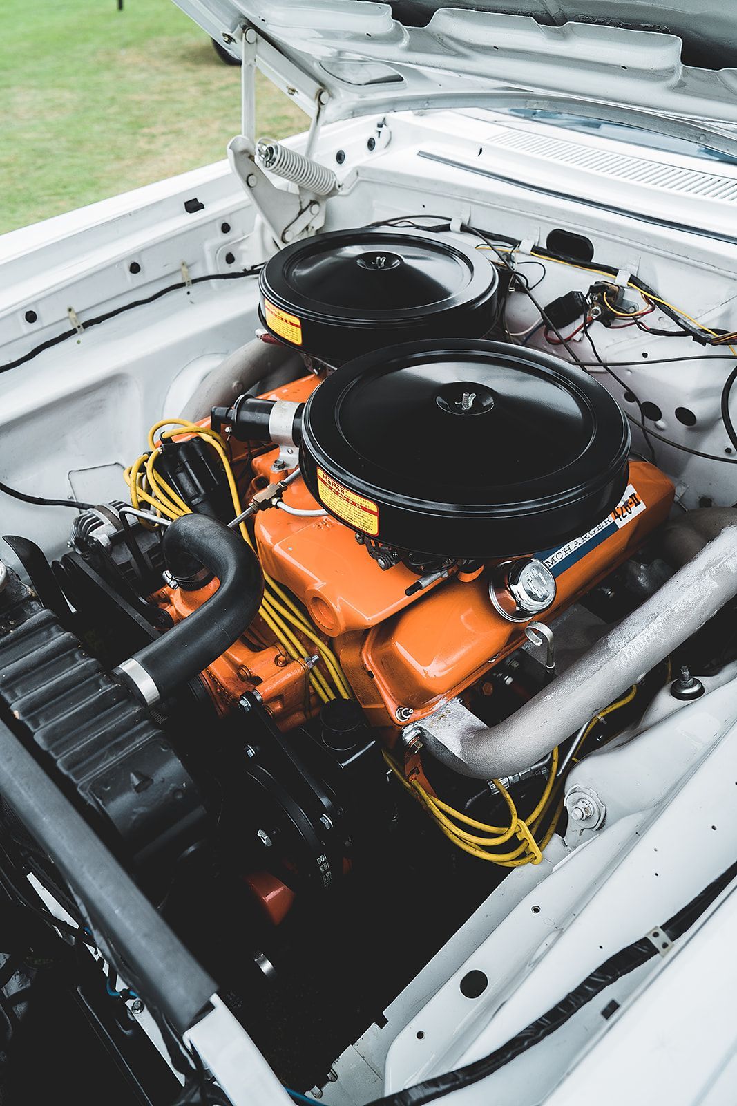 A close up of a car engine with the hood open.
