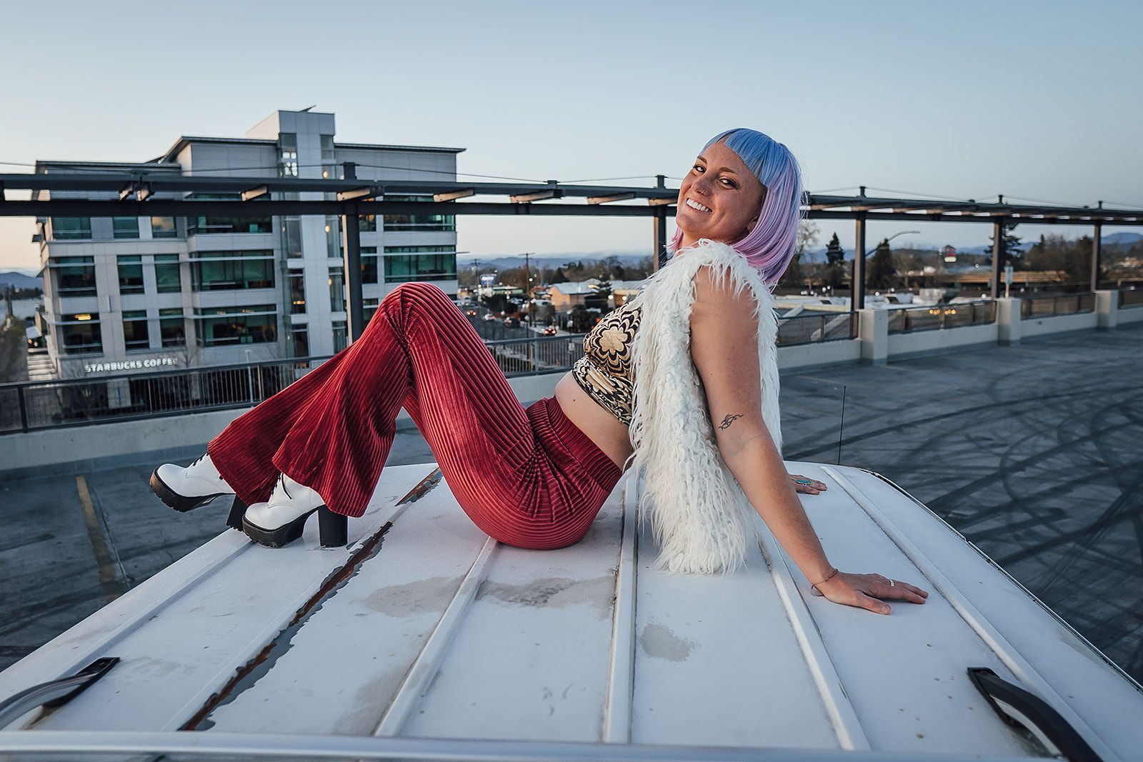 A woman is sitting on the roof of a building.