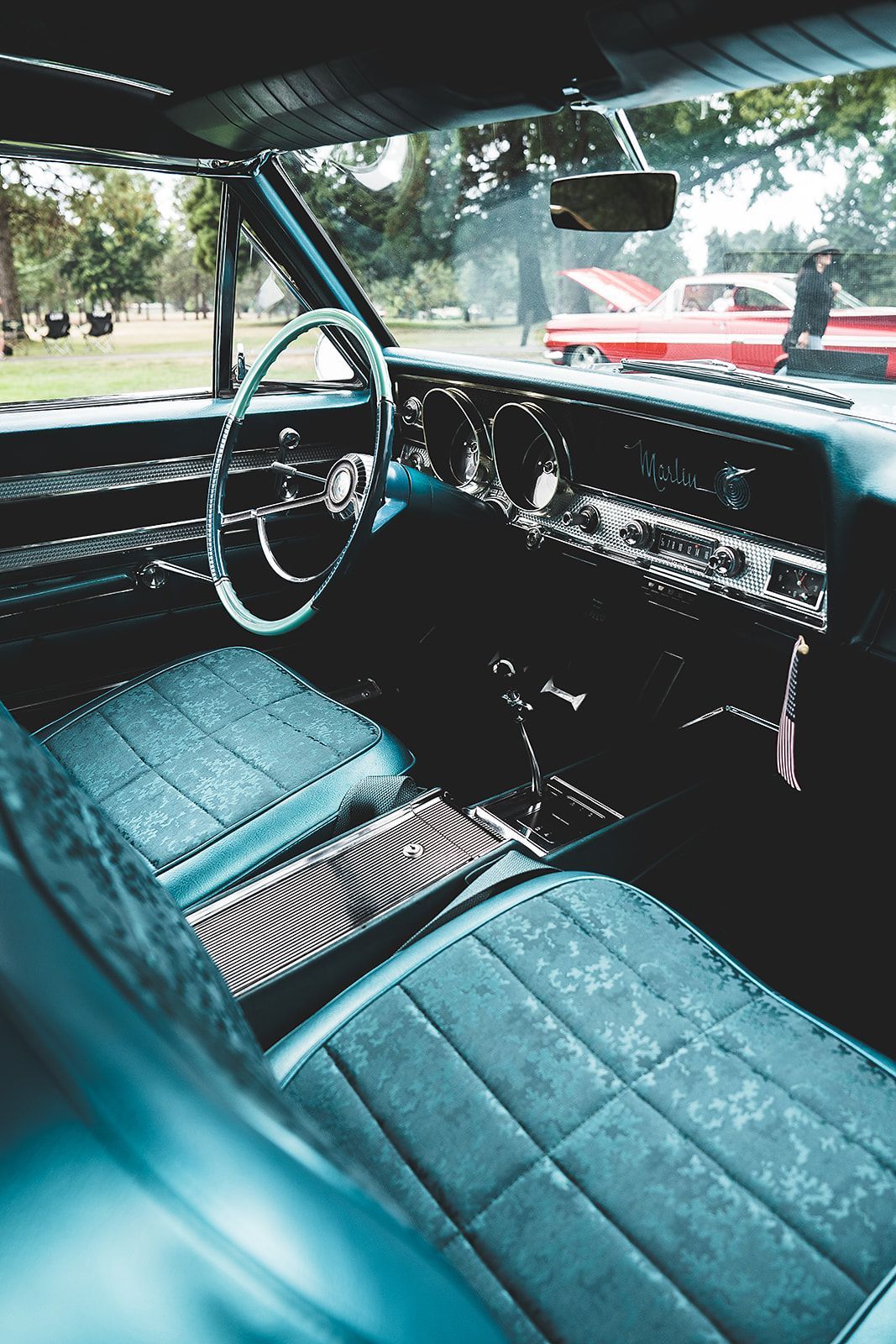 The interior of a blue car with a steering wheel and dashboard.