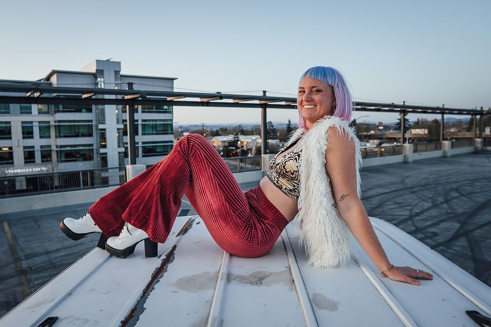 A woman is sitting on the roof of a building.