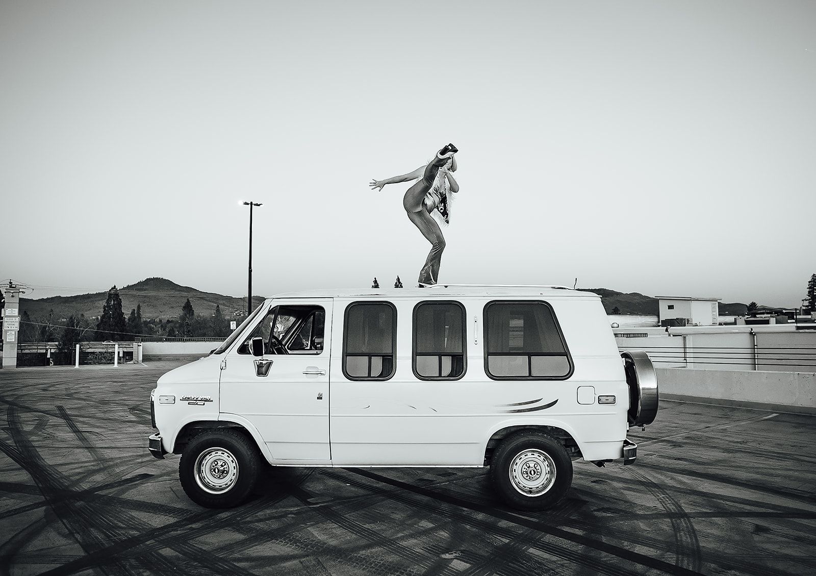 A person is jumping off the roof of a white van