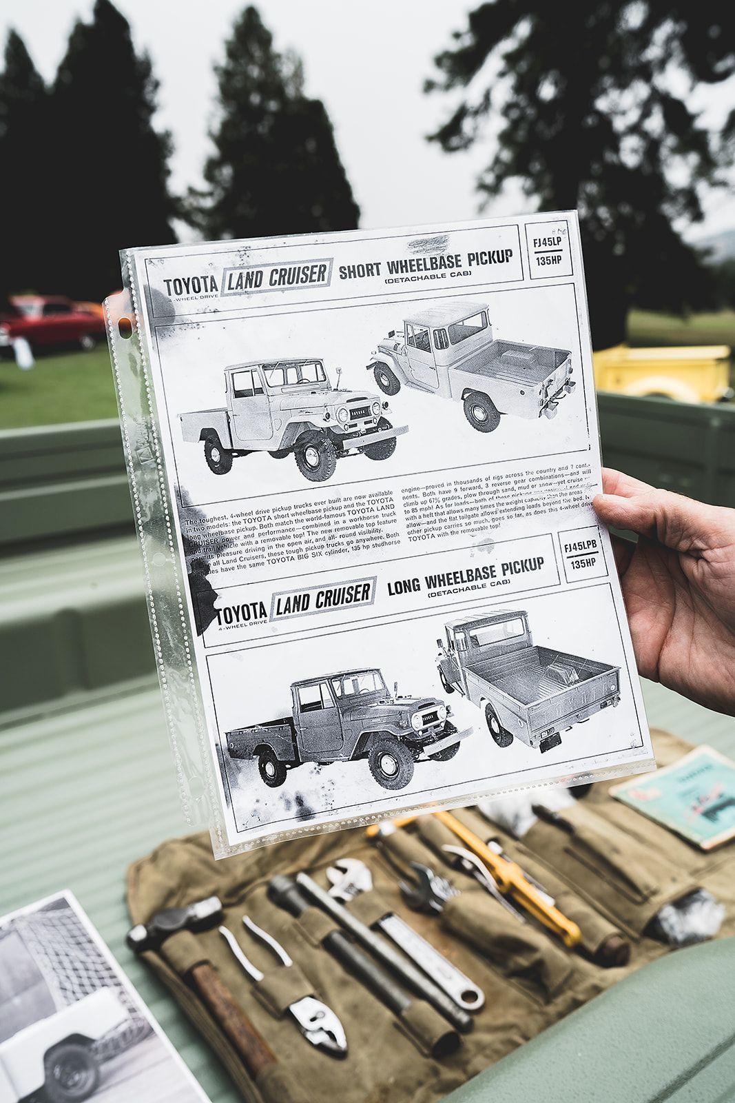 A person is holding a piece of paper with a picture of a truck on it.