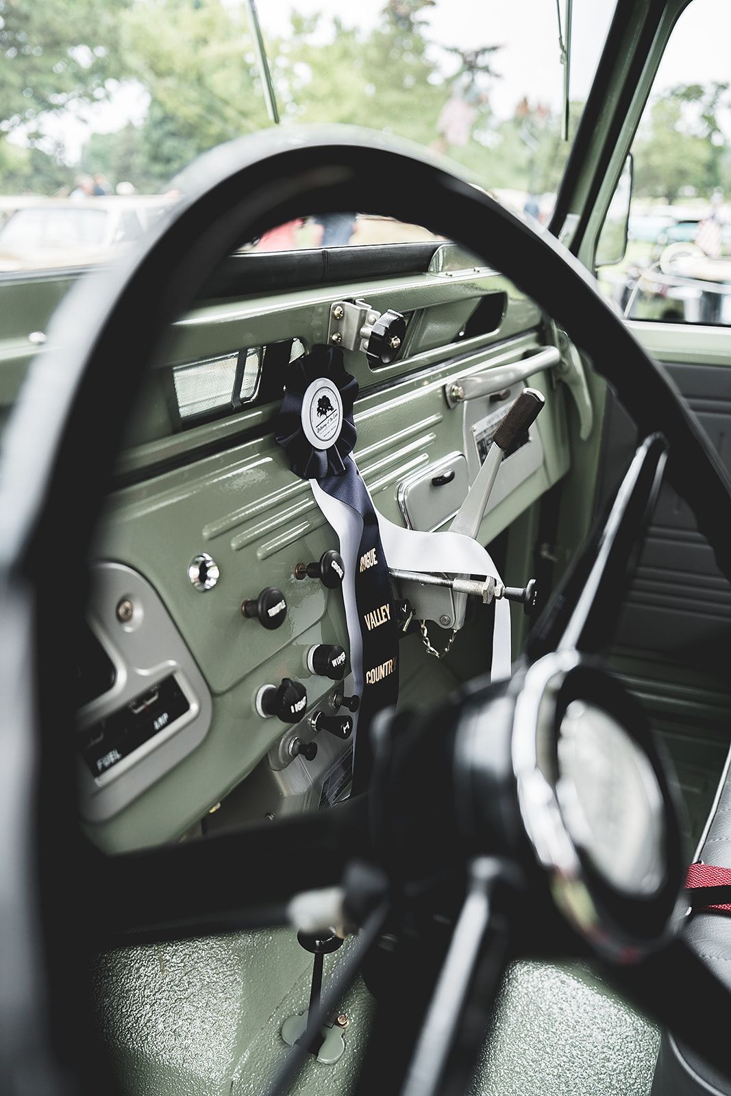 A close up of a car steering wheel and dashboard.