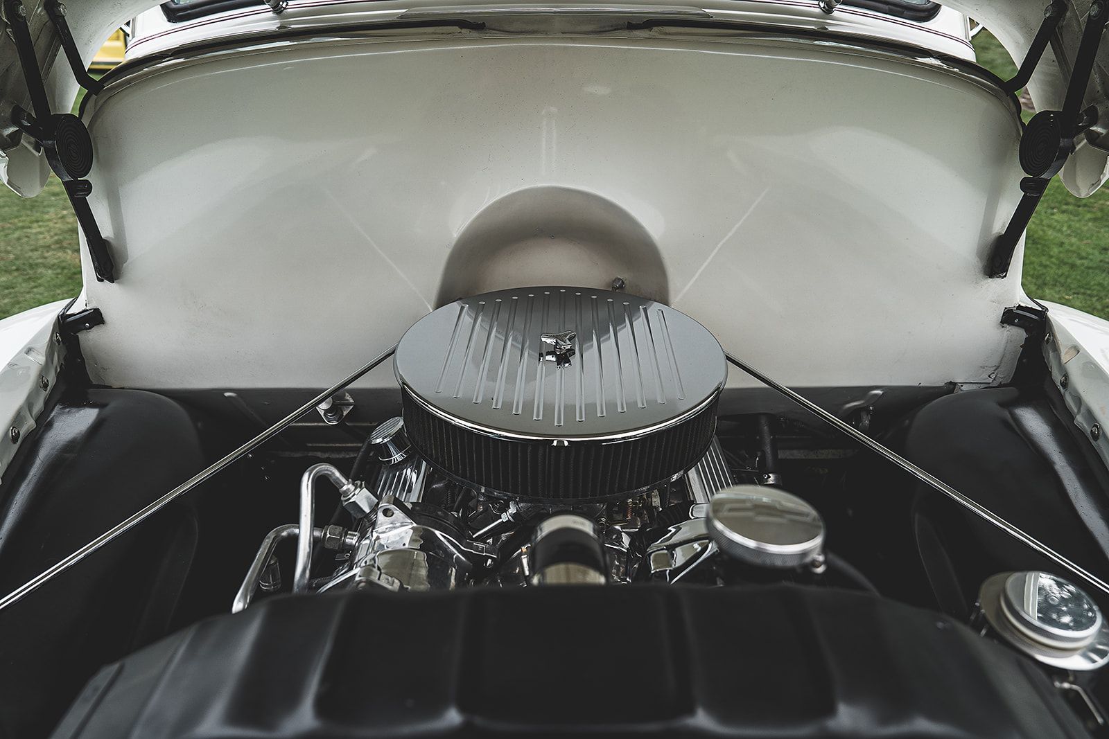 A close up of a car engine with the hood open