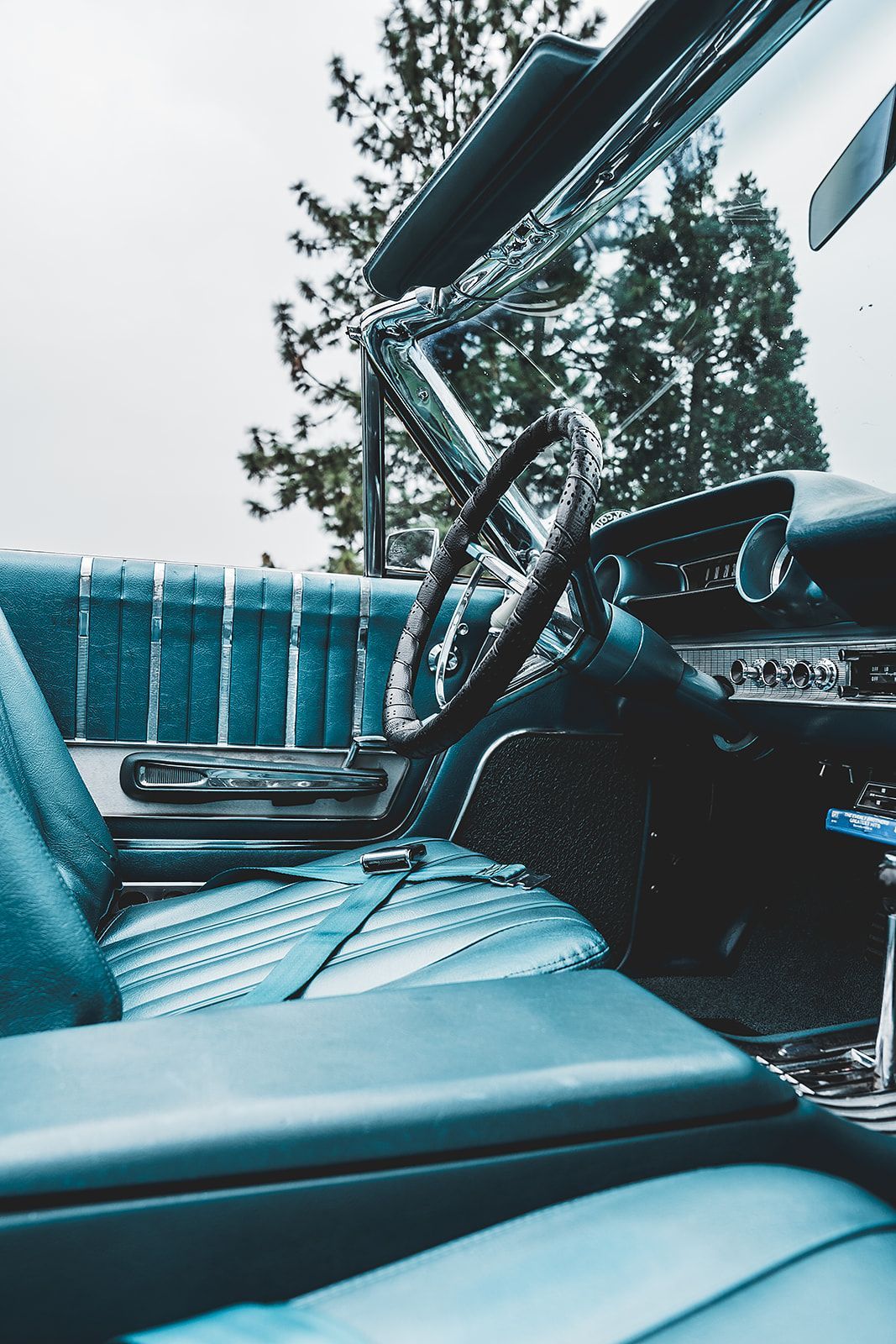 The interior of a car with blue seats and a steering wheel.