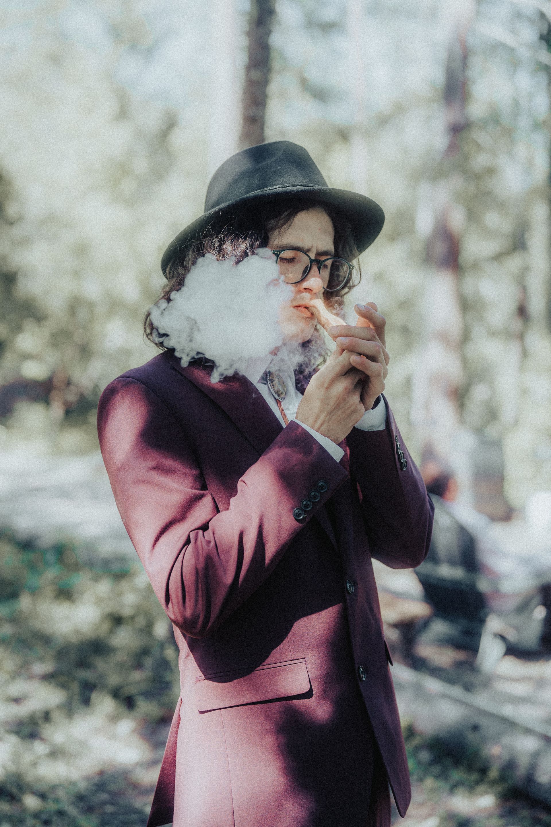 A groom lighting a pipe on his wedding day.
