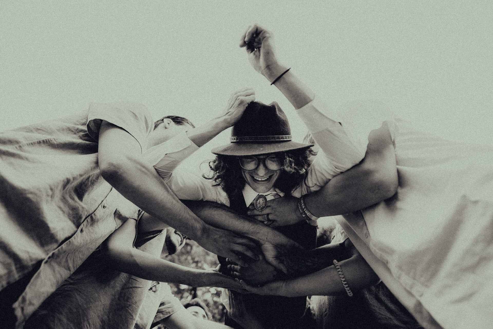 A black and white photo of a woman in a cowboy hat surrounded by people.