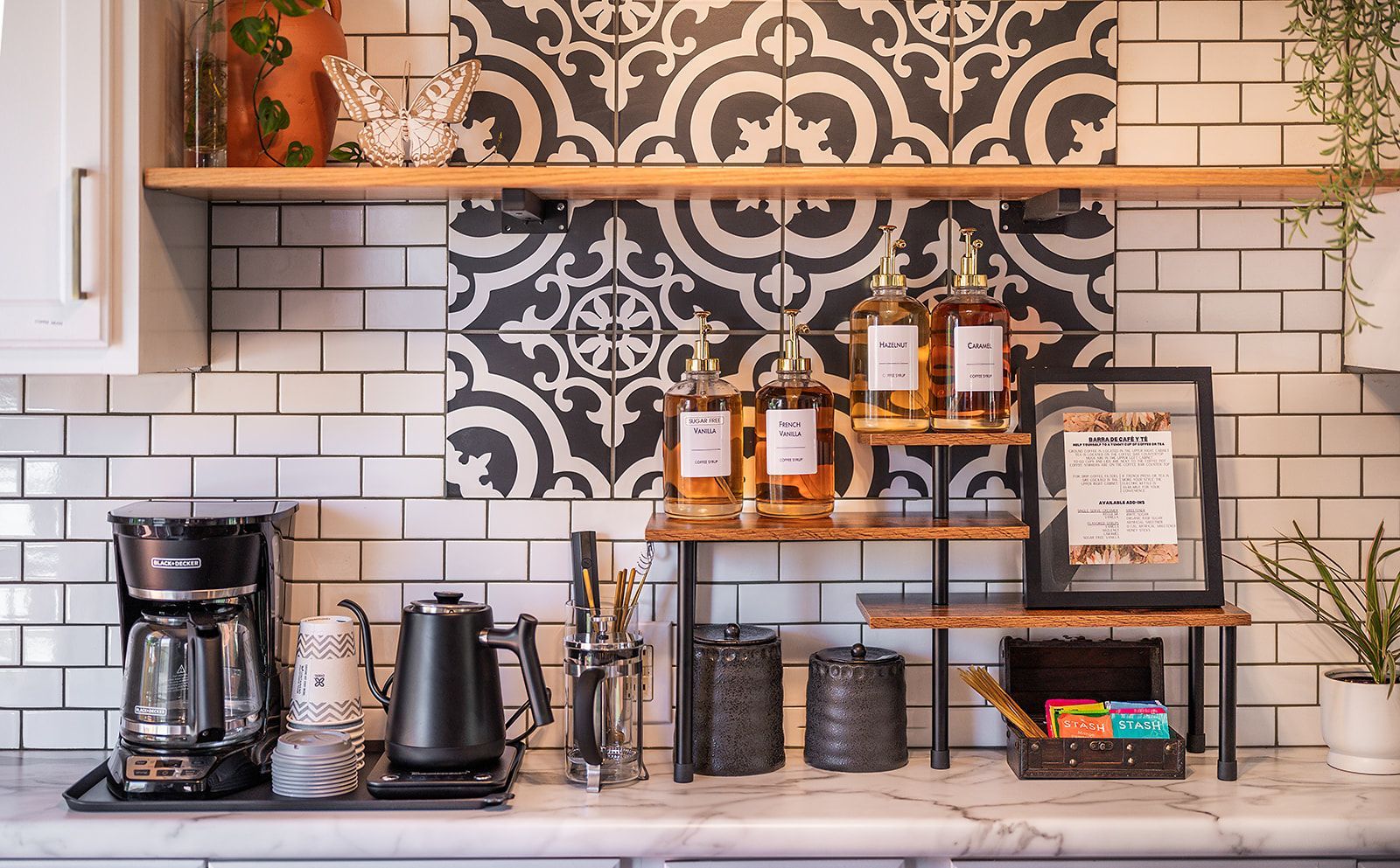 A kitchen with a coffee maker , pots and pans on the counter.