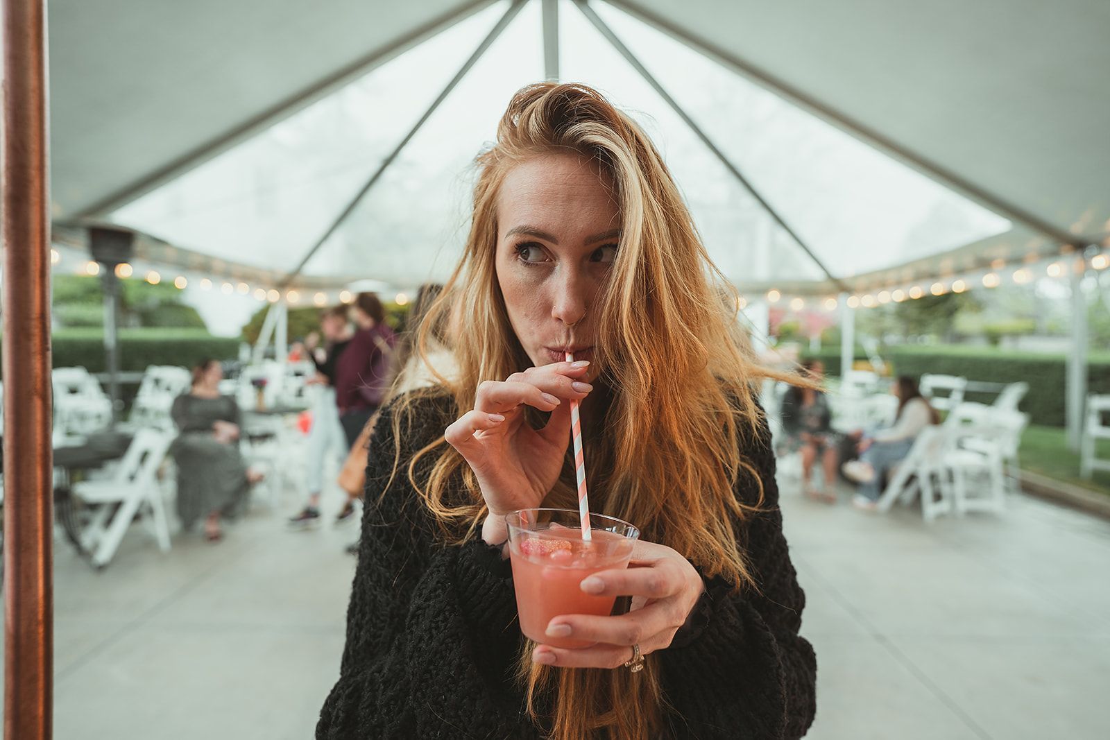 A woman is drinking a drink through a straw.