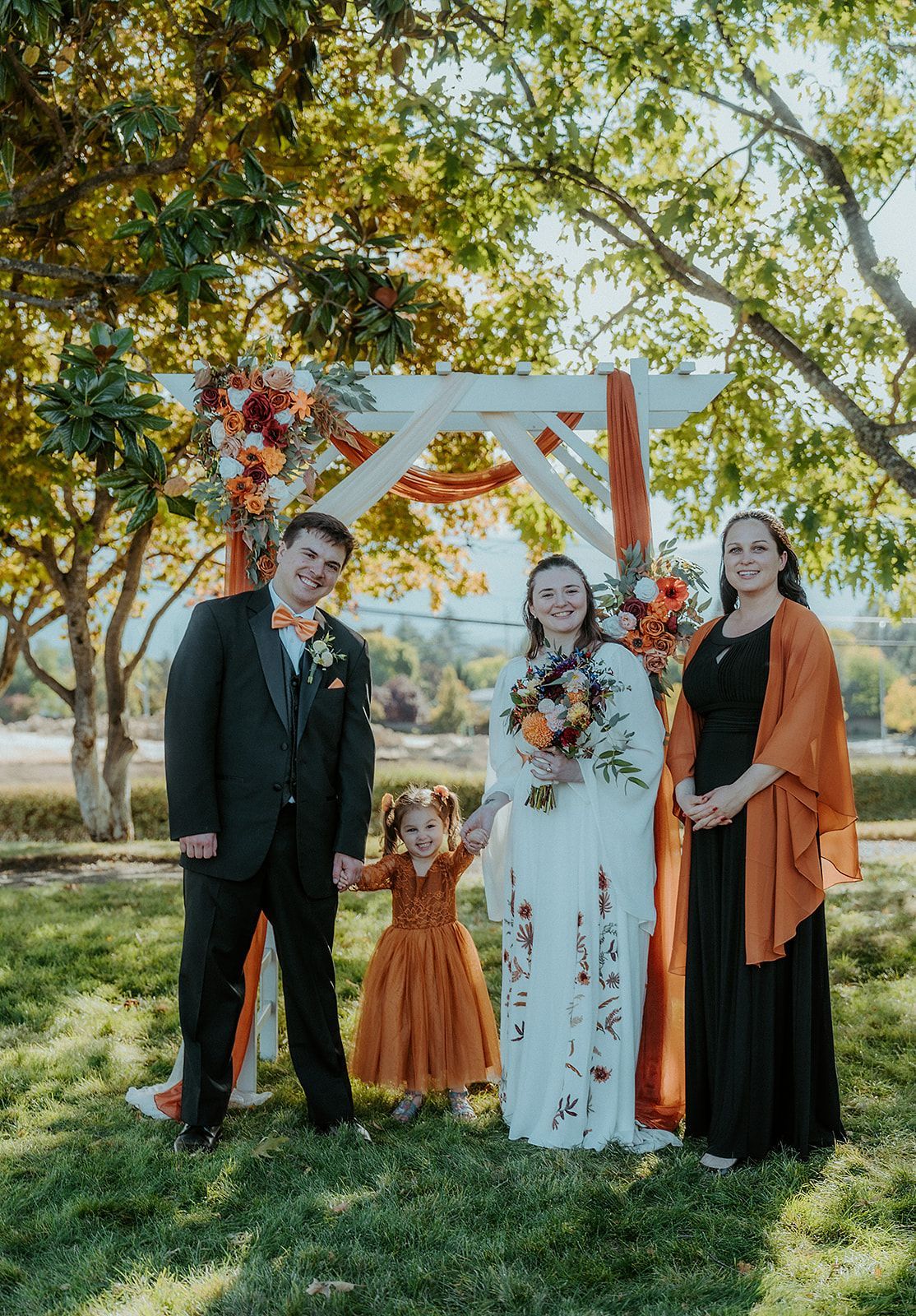 A bride and groom are posing for a picture with their wedding party.