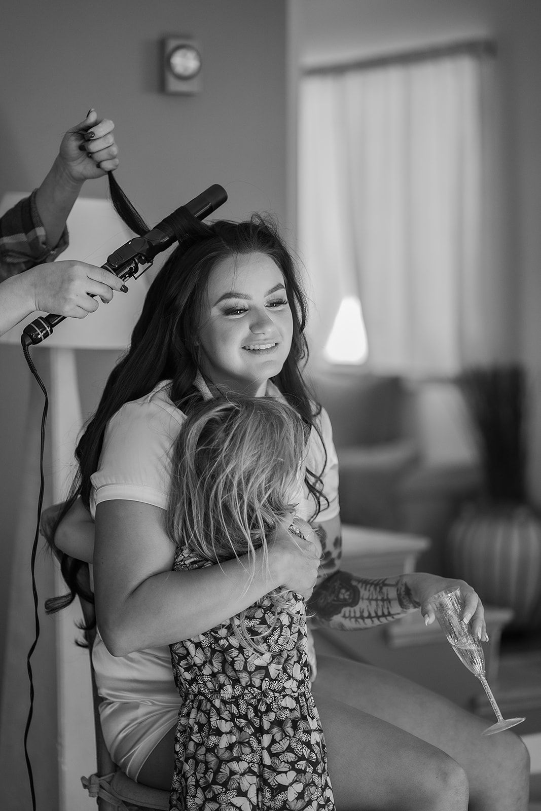 A woman is getting her hair done while holding a doll.