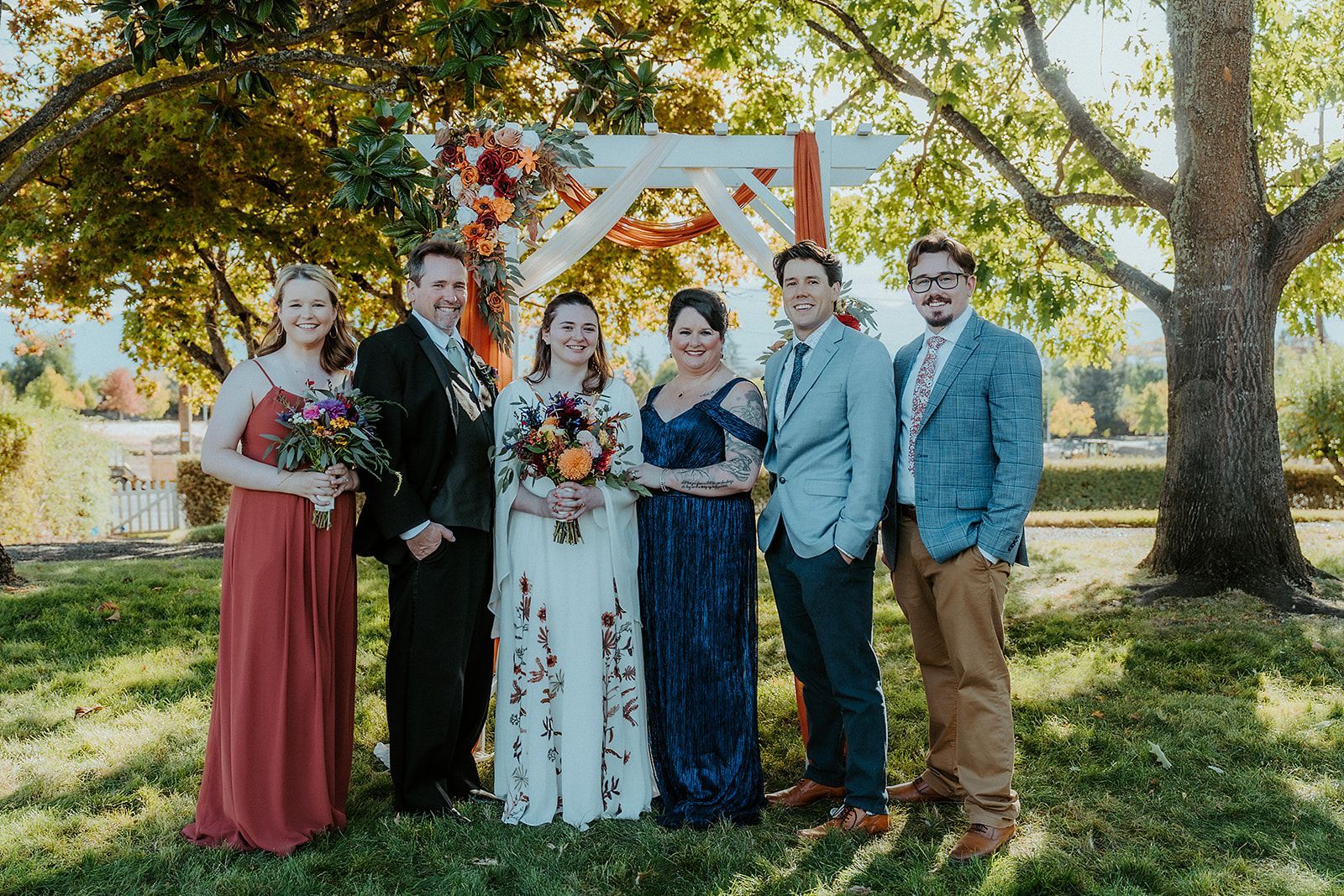 A group of people are posing for a picture at a wedding.