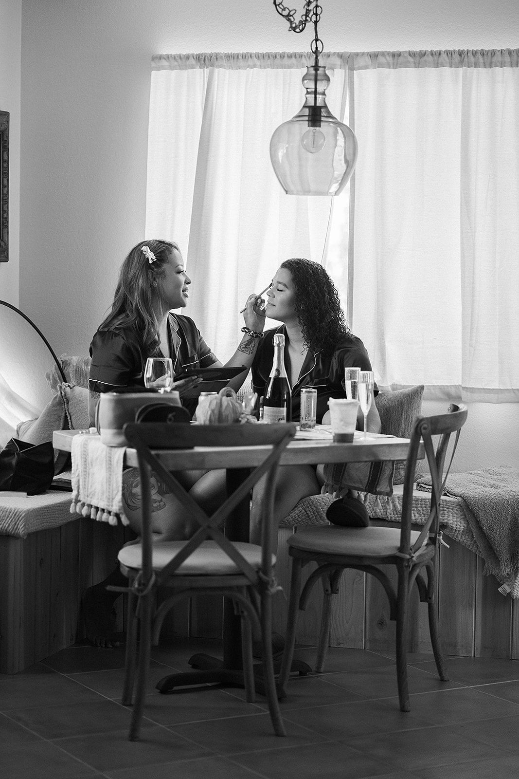 Two women are sitting at a table in a black and white photo.