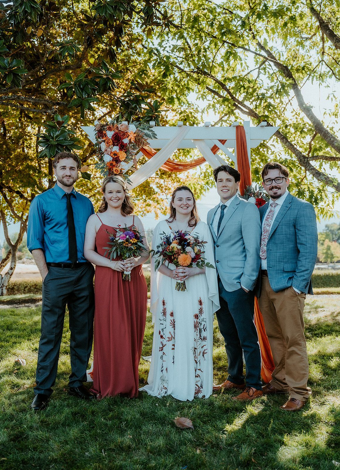 A bride and groom are posing for a picture with their wedding party.