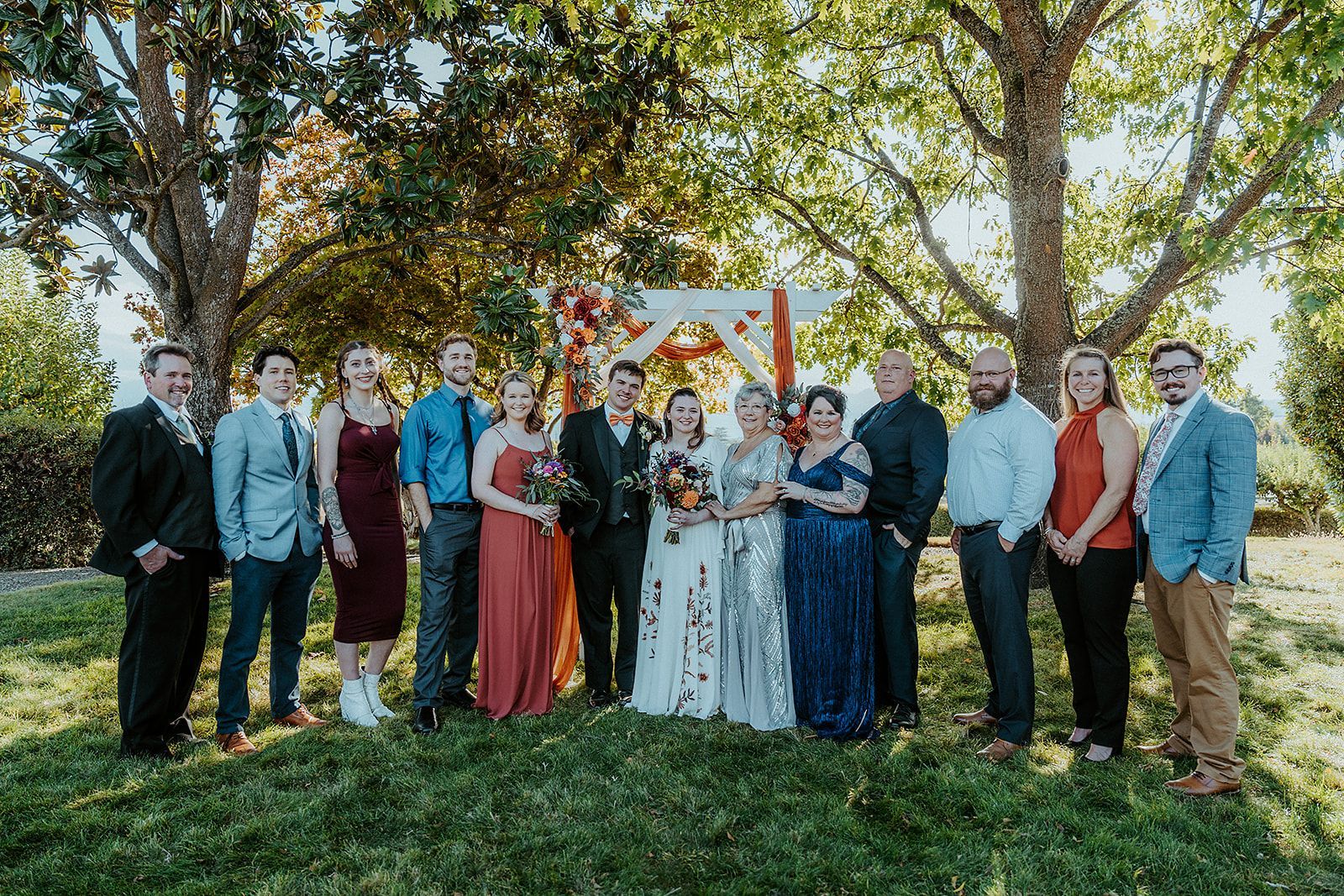 A group of people are posing for a picture at a wedding.