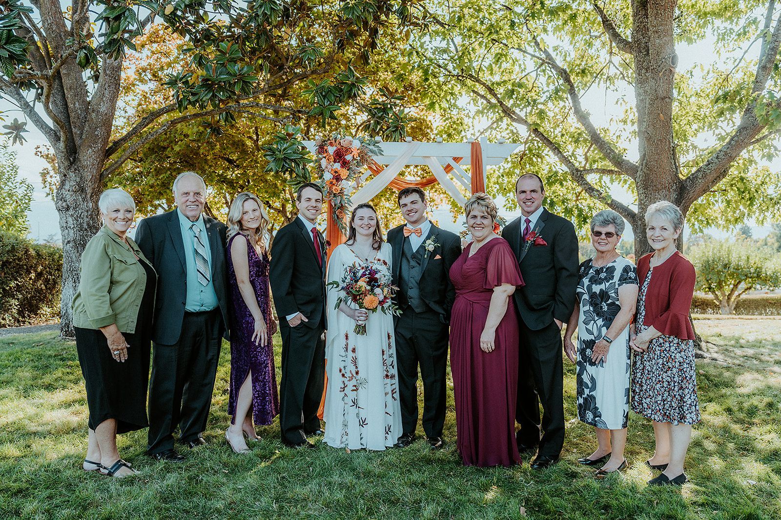 A group of people are posing for a picture at a wedding.