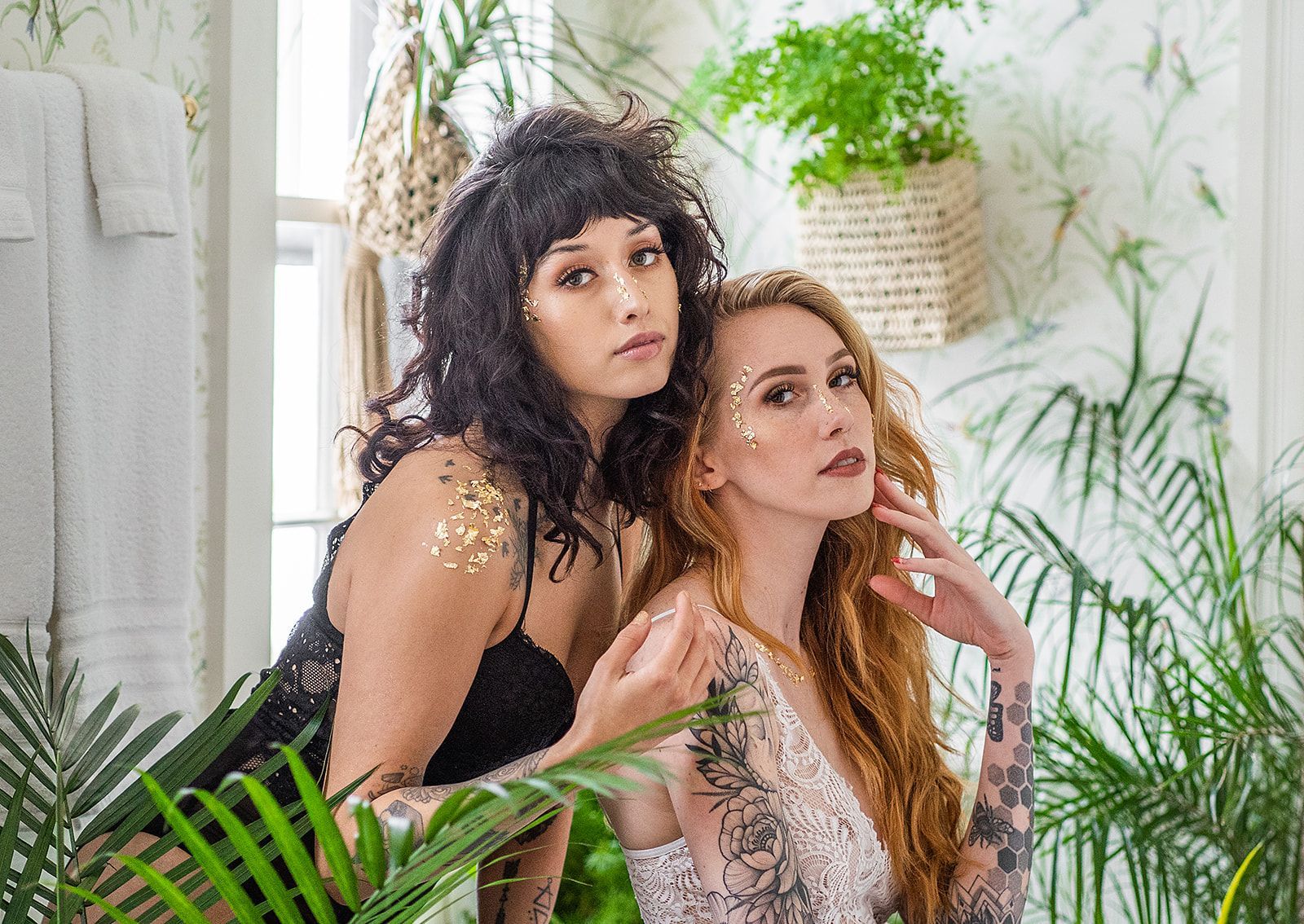 Two women are standing next to each other in a bathroom surrounded by plants.