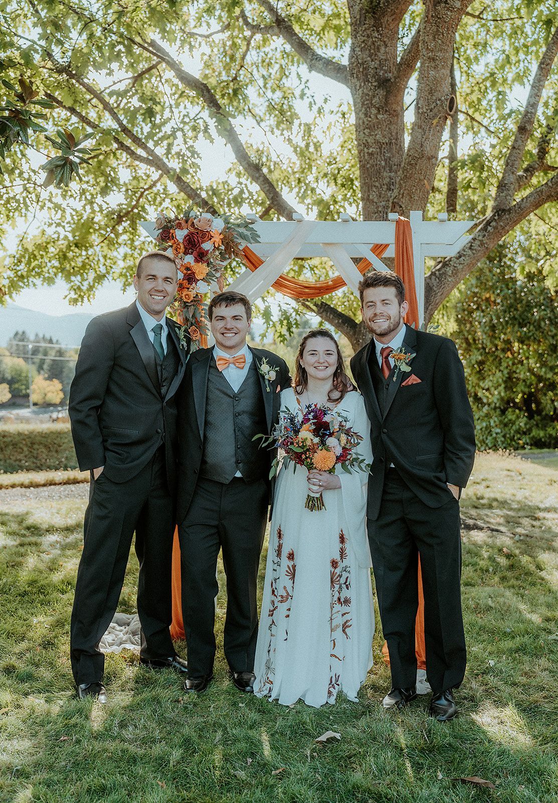 A bride and groom are posing for a picture with their parents.