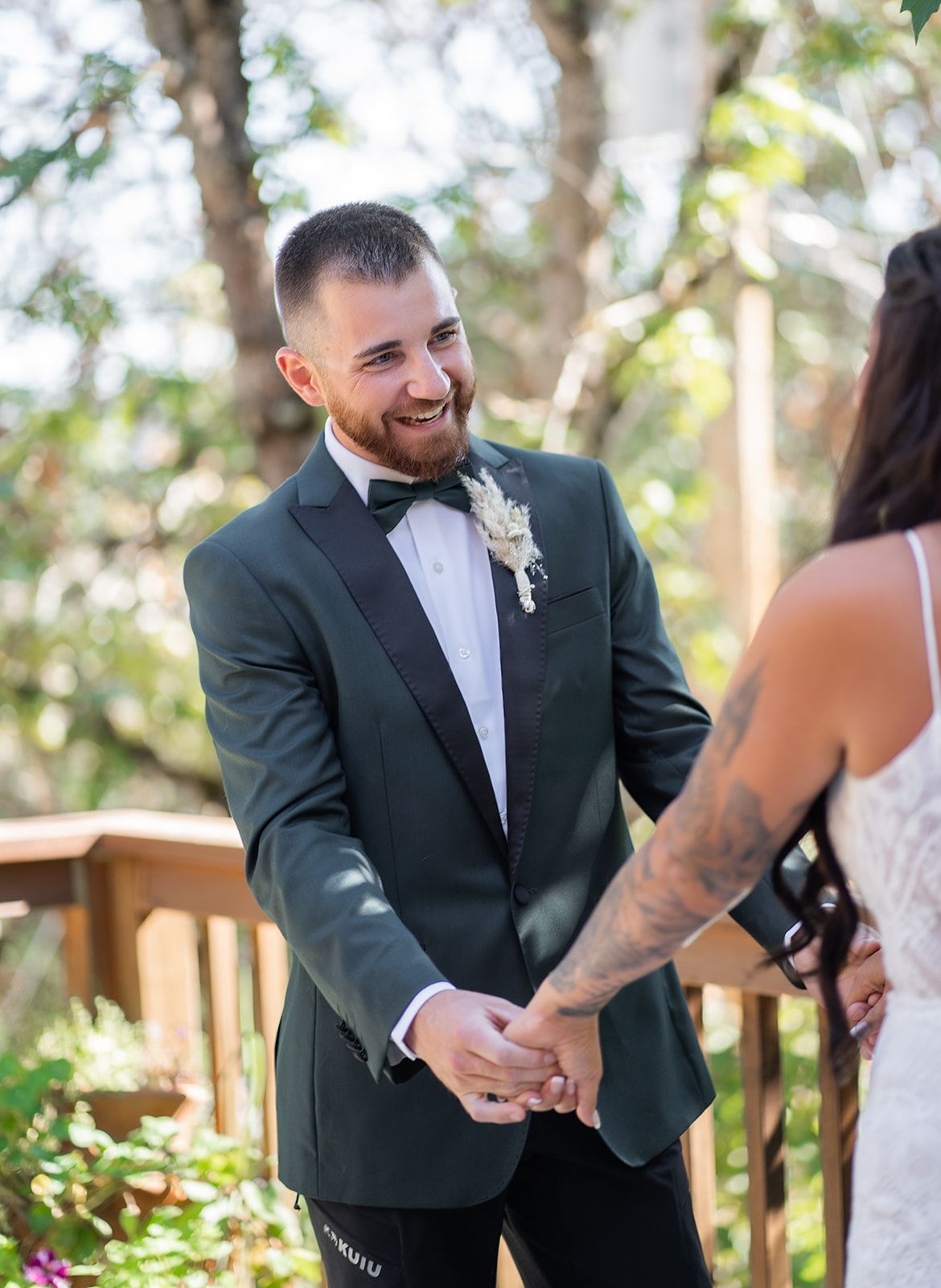 A bride and groom are holding hands during their first look at their wedding.