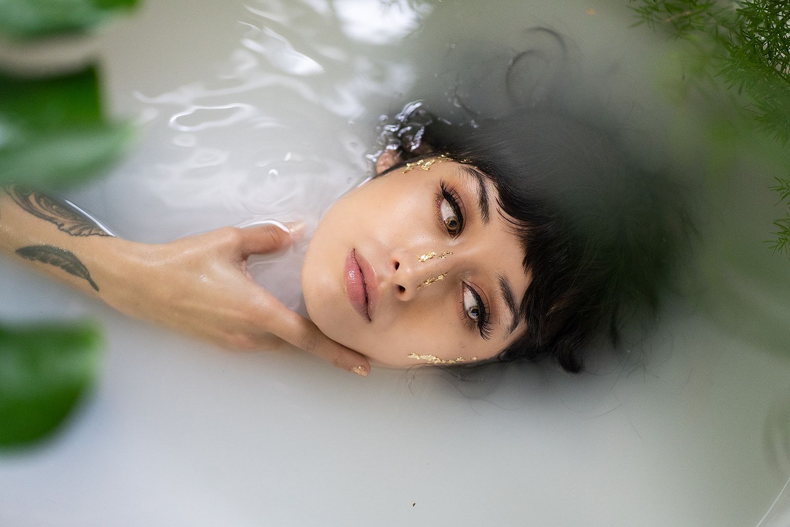 A woman is laying in a bathtub filled with milk.