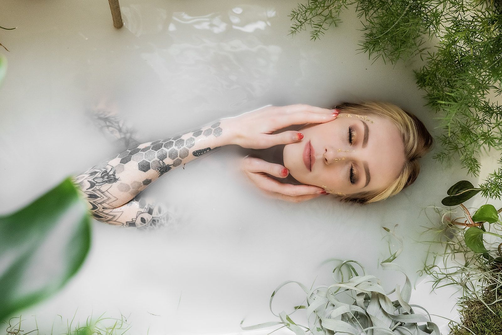 A woman is laying in a bathtub filled with bubbles.