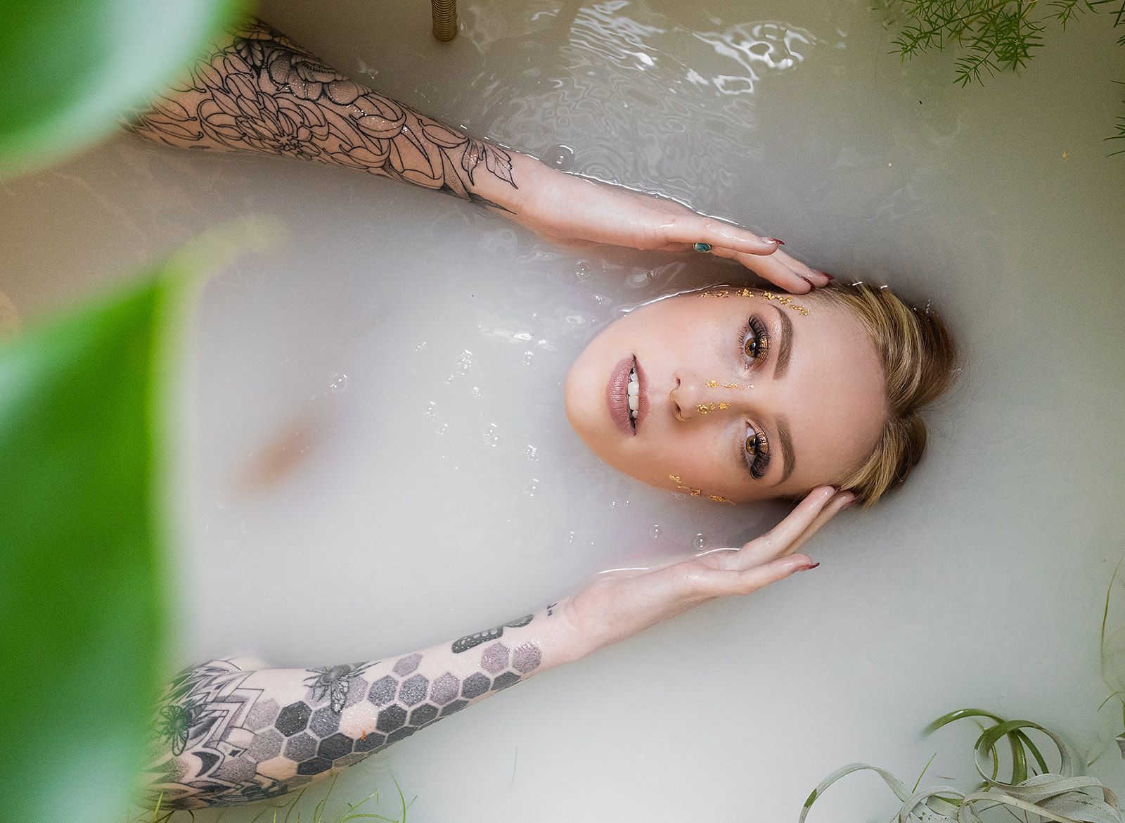 A woman is laying in a bathtub filled with milk.