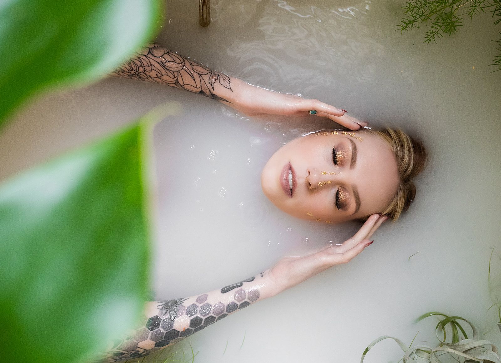 A woman is laying in a bathtub filled with milk.