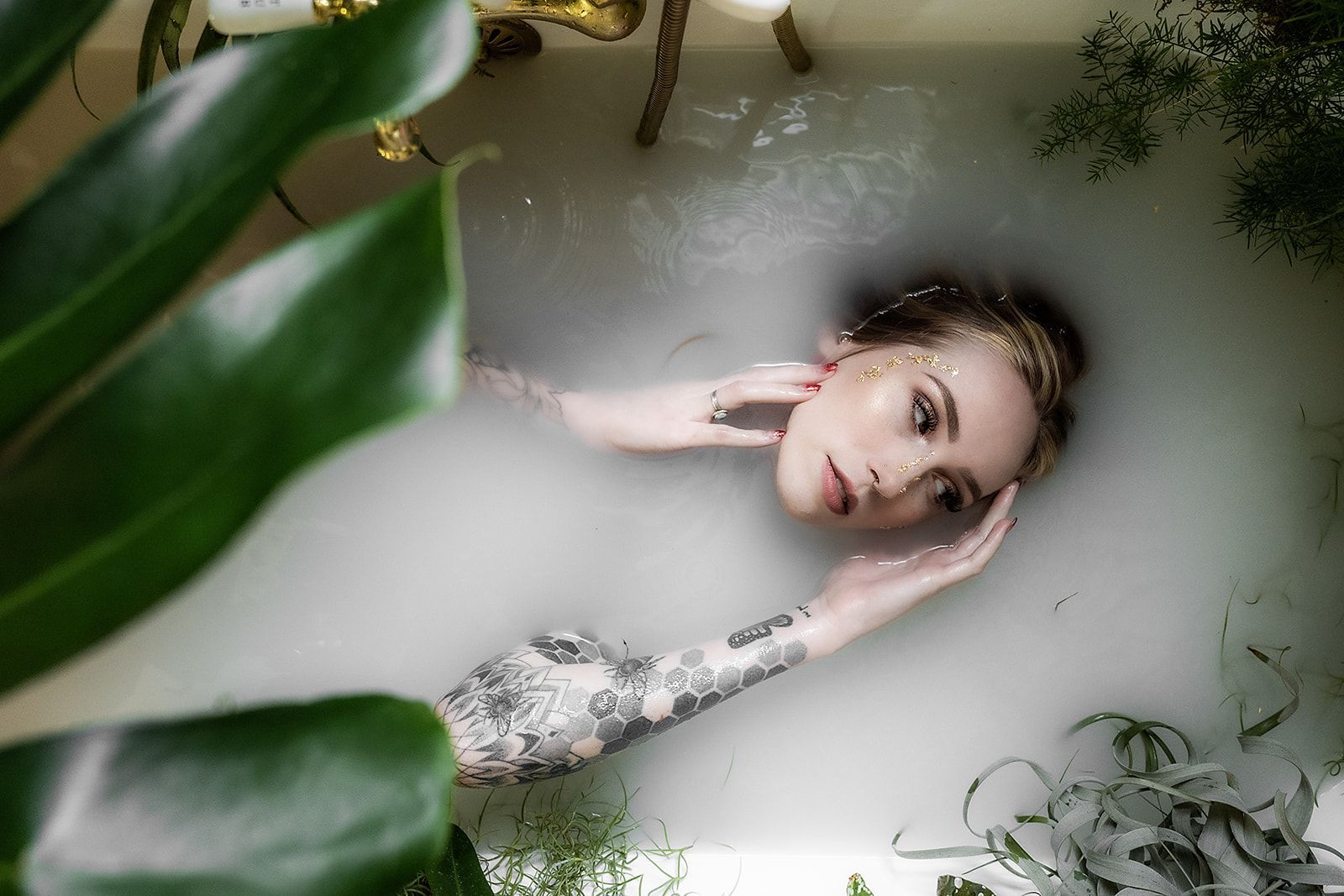 A woman is laying in a bathtub filled with milk.