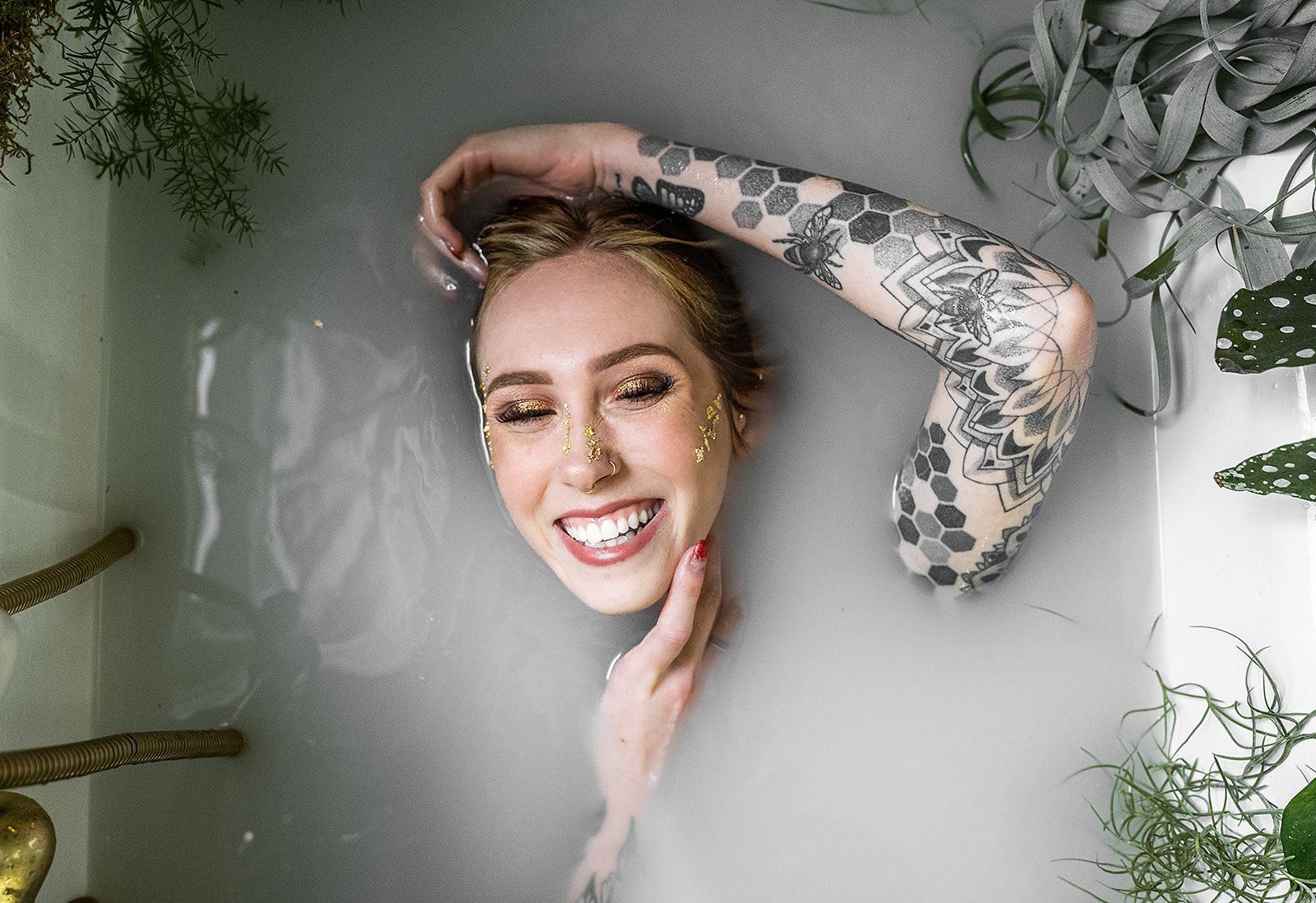 A woman with tattoos is taking a bath in milk.