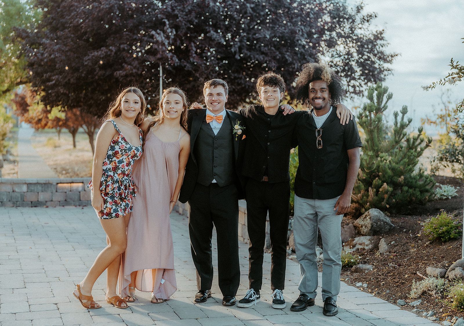 A group of people are posing for a picture together on a sidewalk.