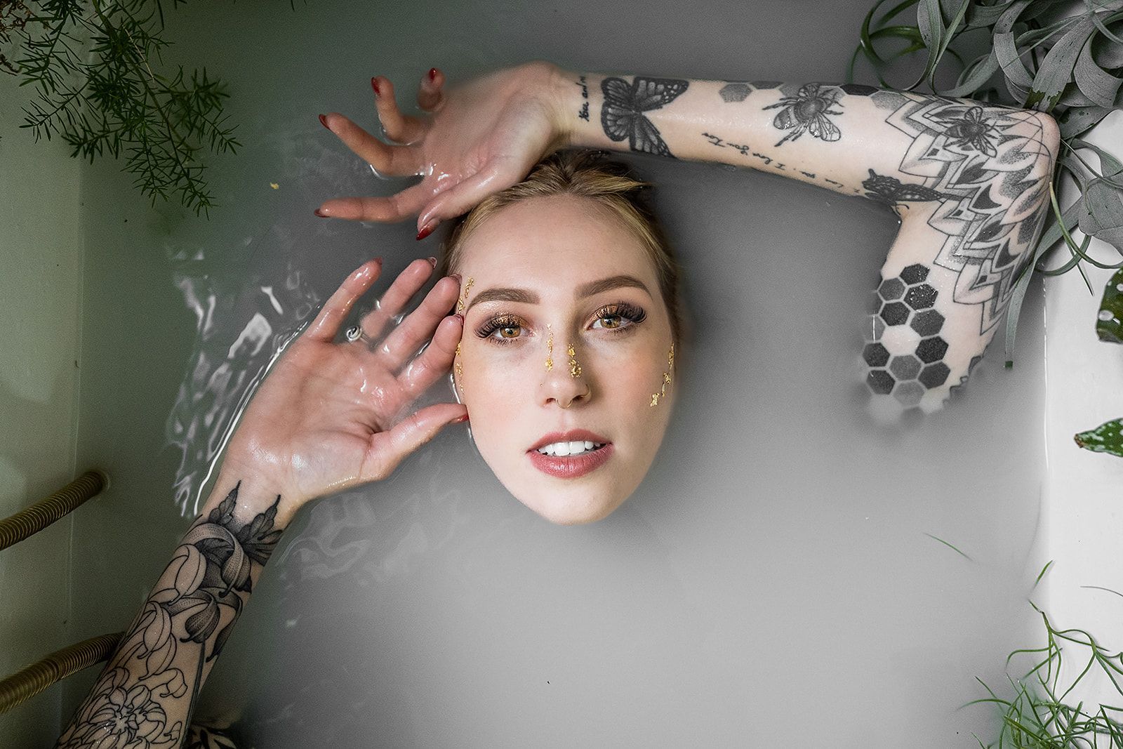 A woman is laying in a bathtub with her head in the water.