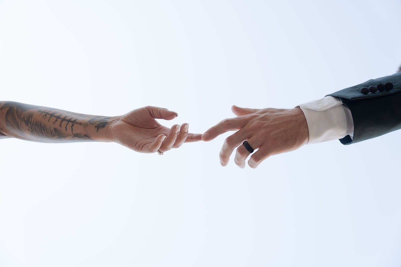 A man and a woman are reaching for each other 's hands.