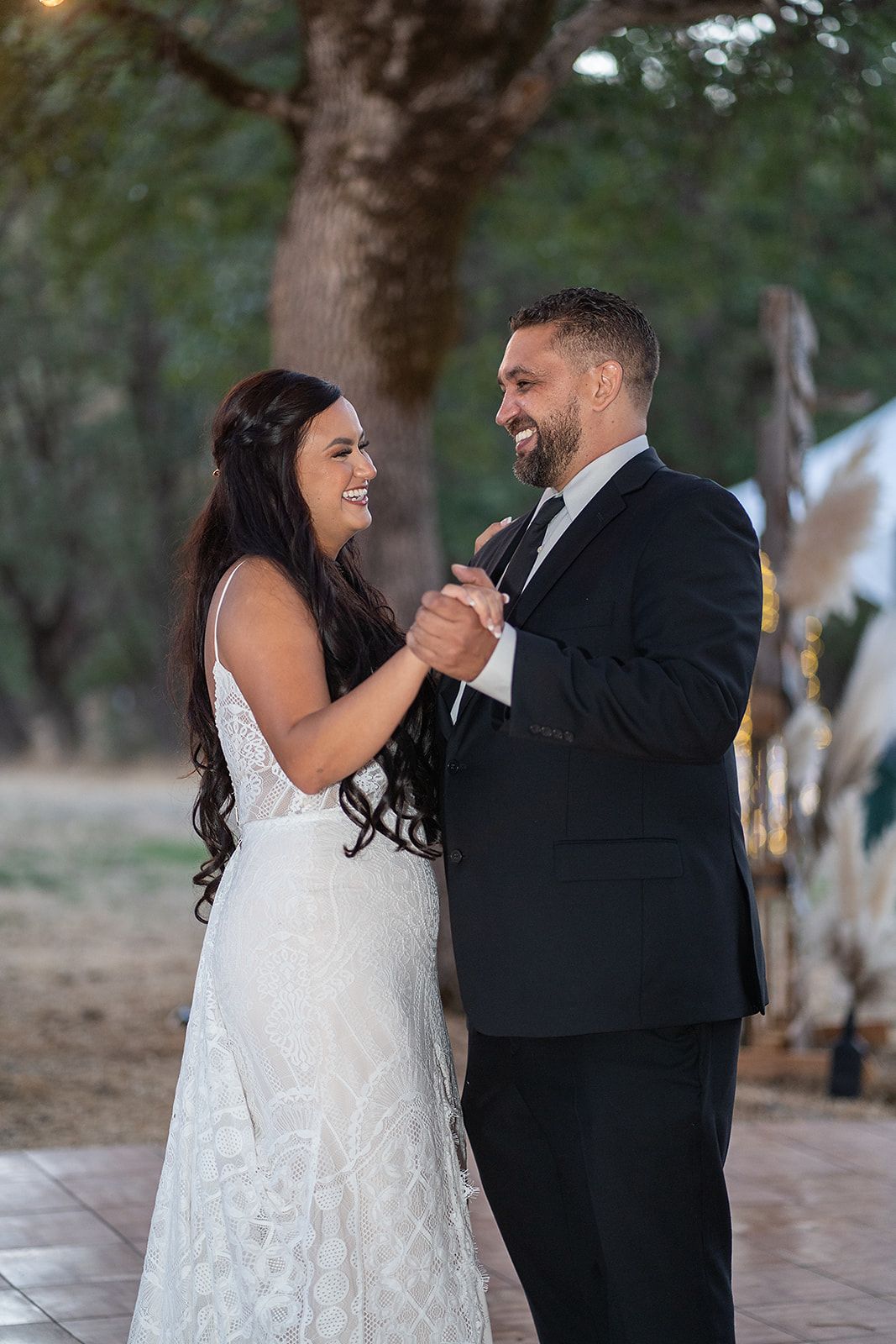 A bride and groom are dancing together at their wedding reception.