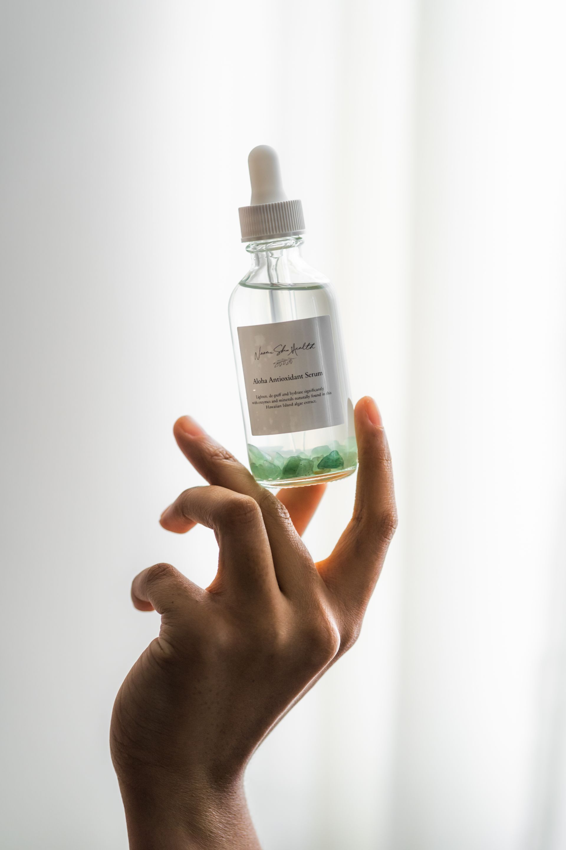 A person is holding a bottle of liquid in their hand.