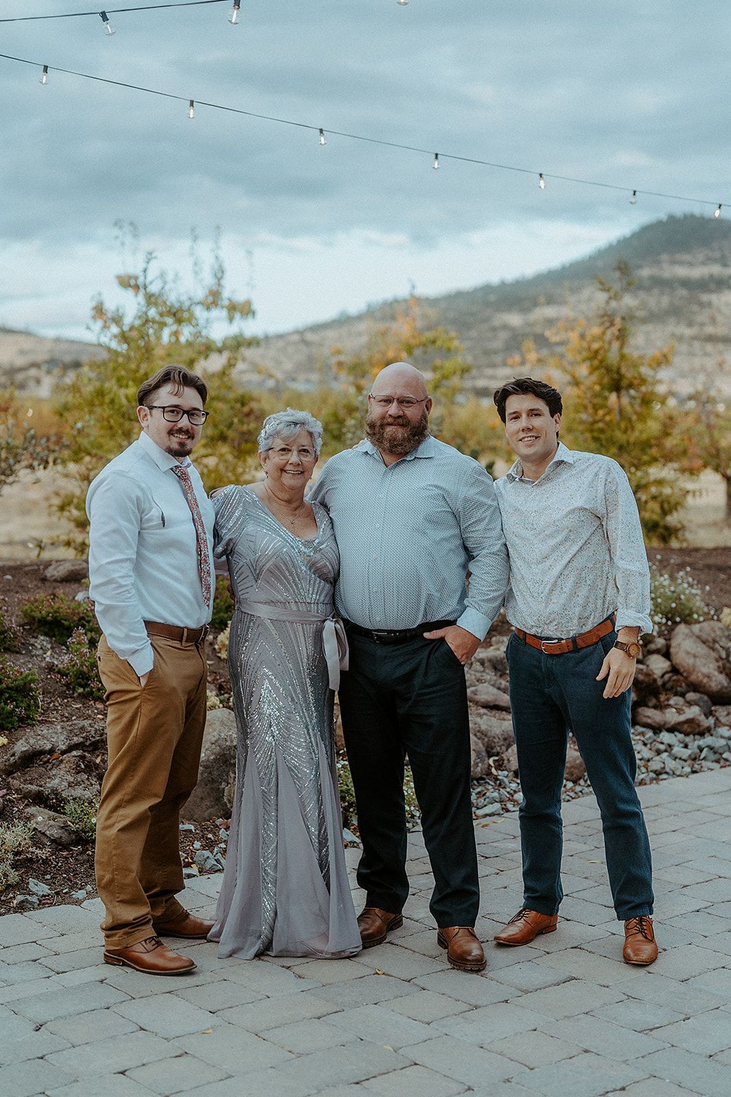 A group of people standing next to each other on a sidewalk.