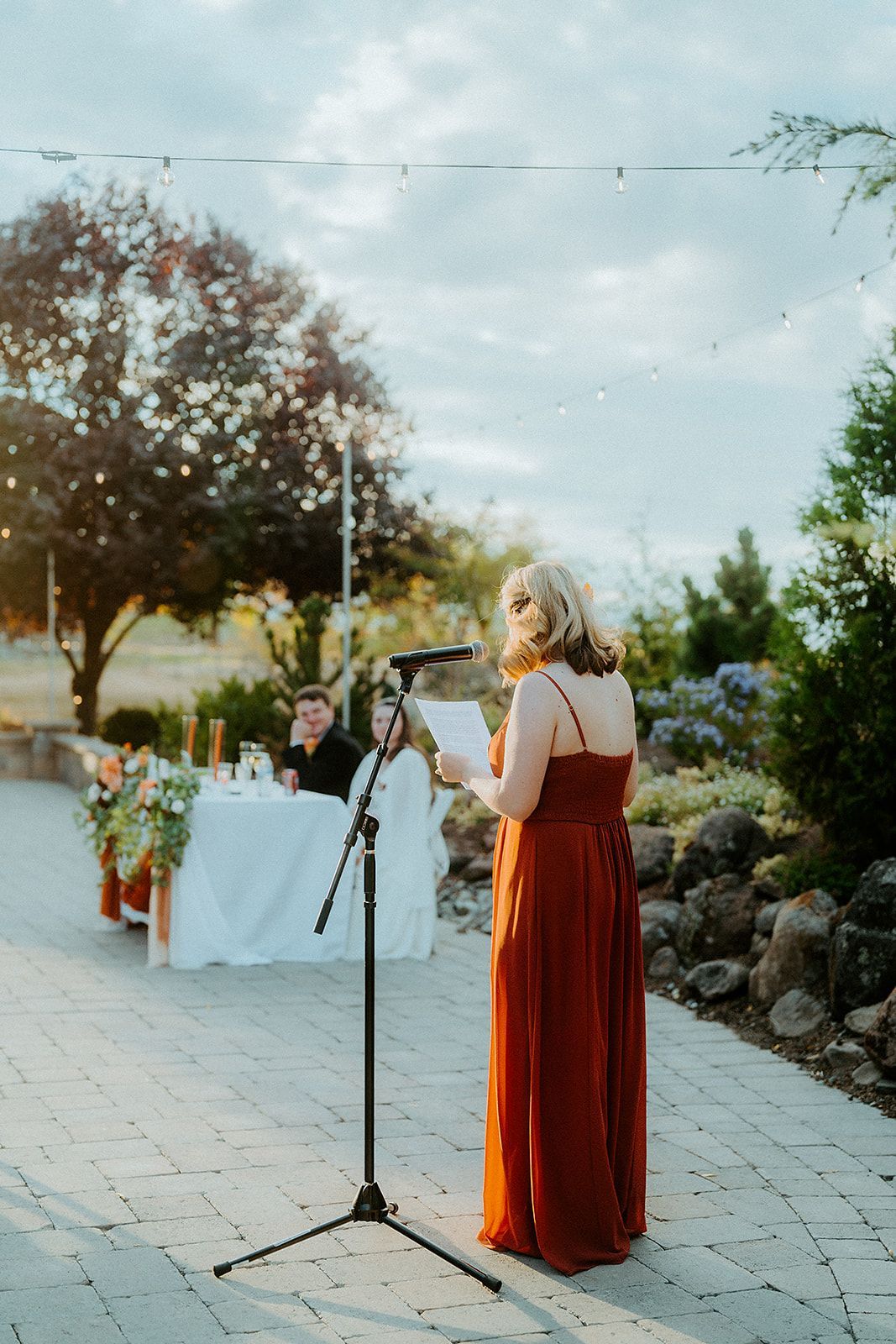 A woman in a red dress is standing in front of a microphone.