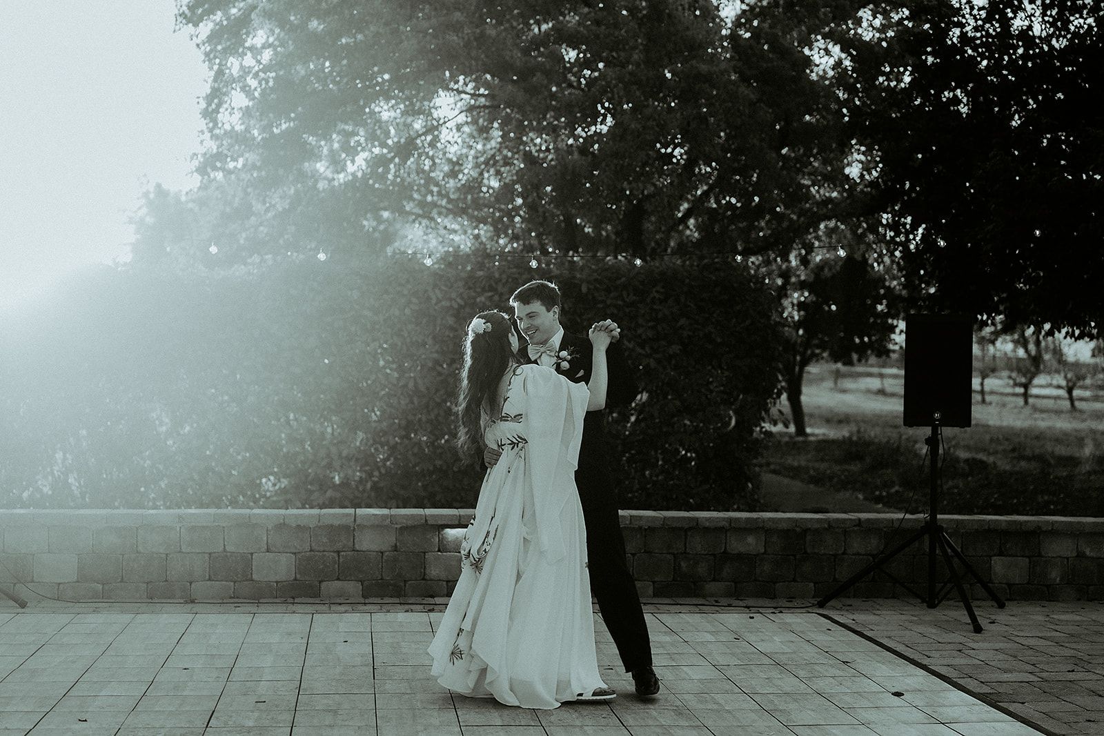 A black and white photo of a bride and groom dancing.