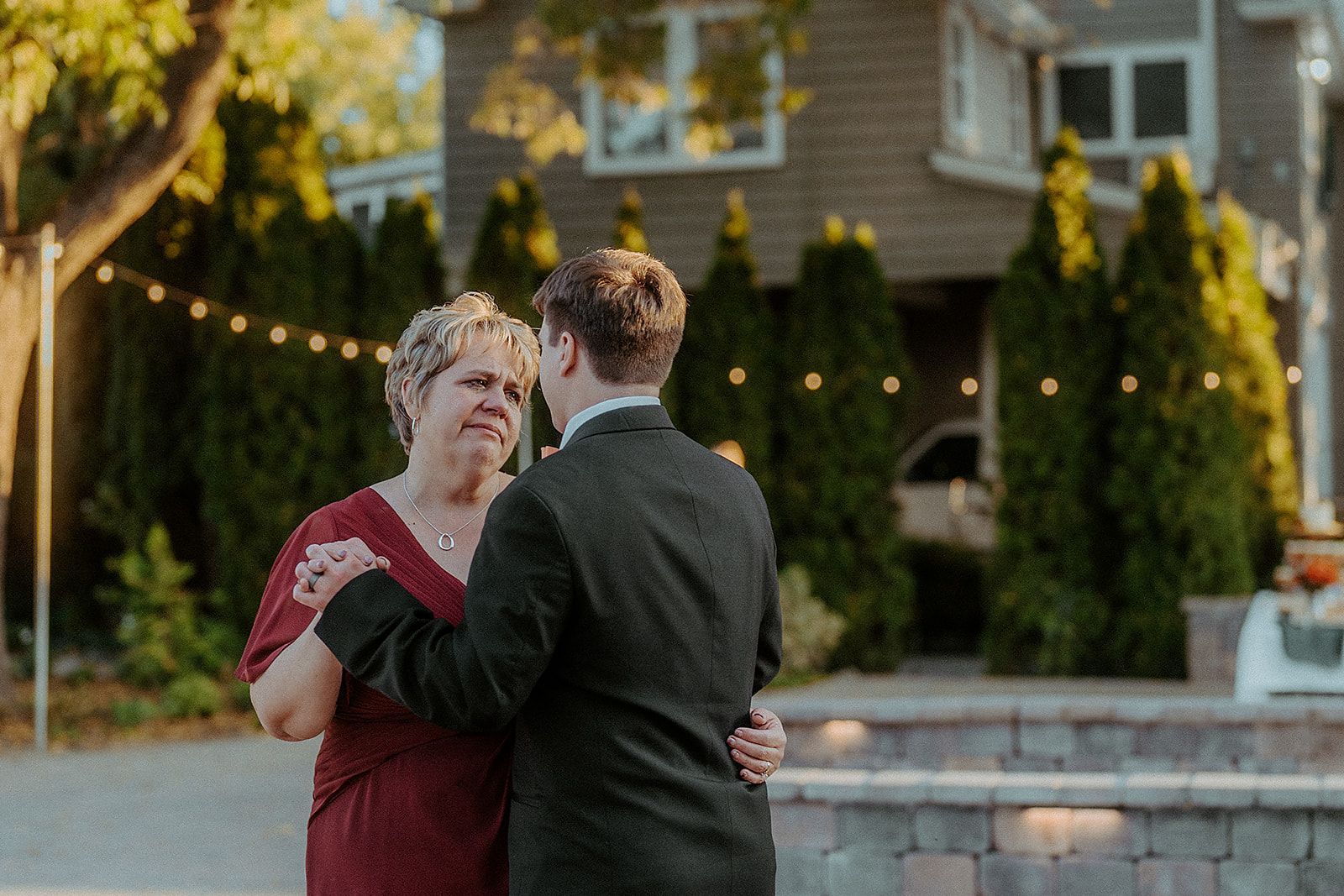 A man and a woman are dancing in front of a house.