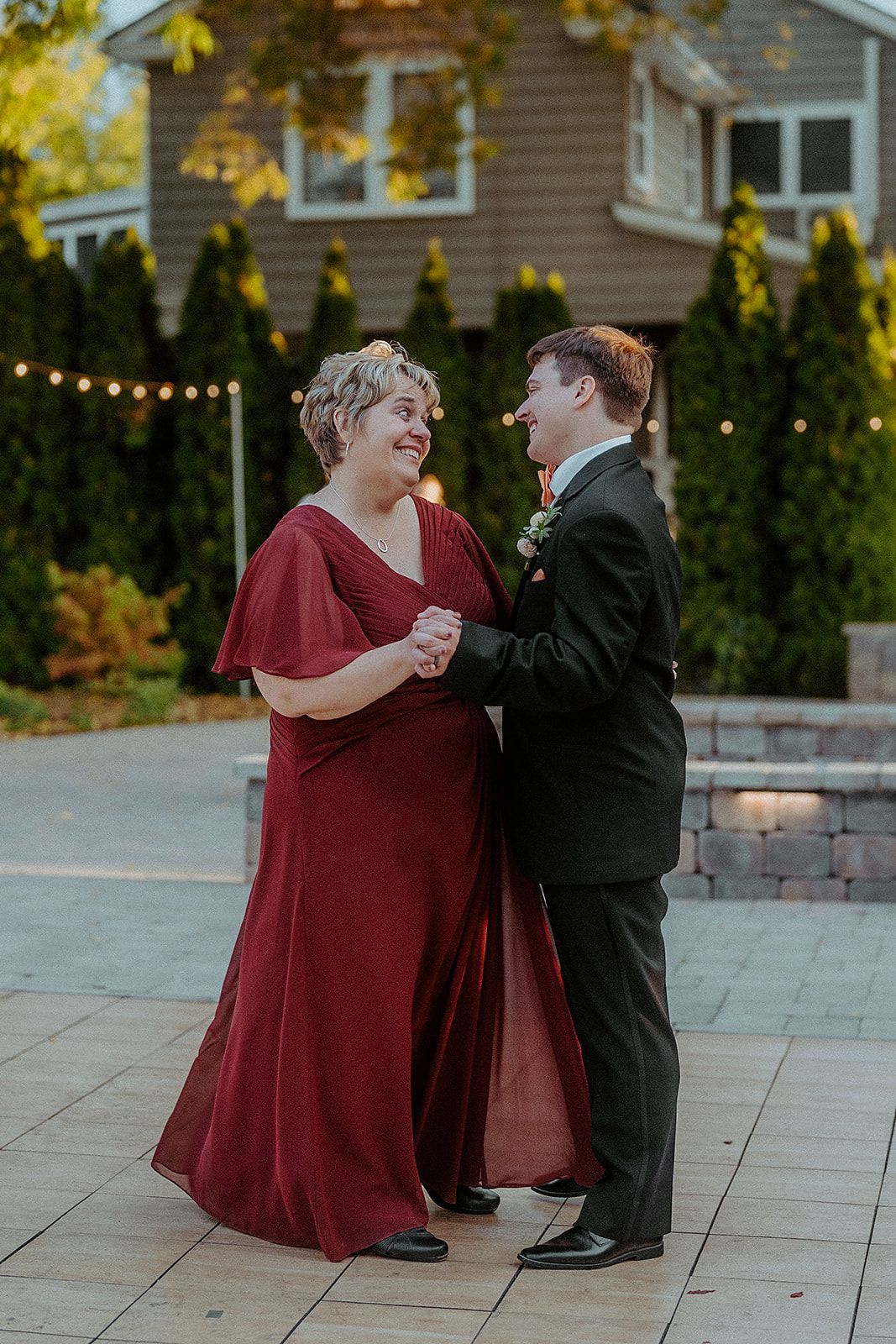 A woman in a red dress is dancing with a man in a suit.